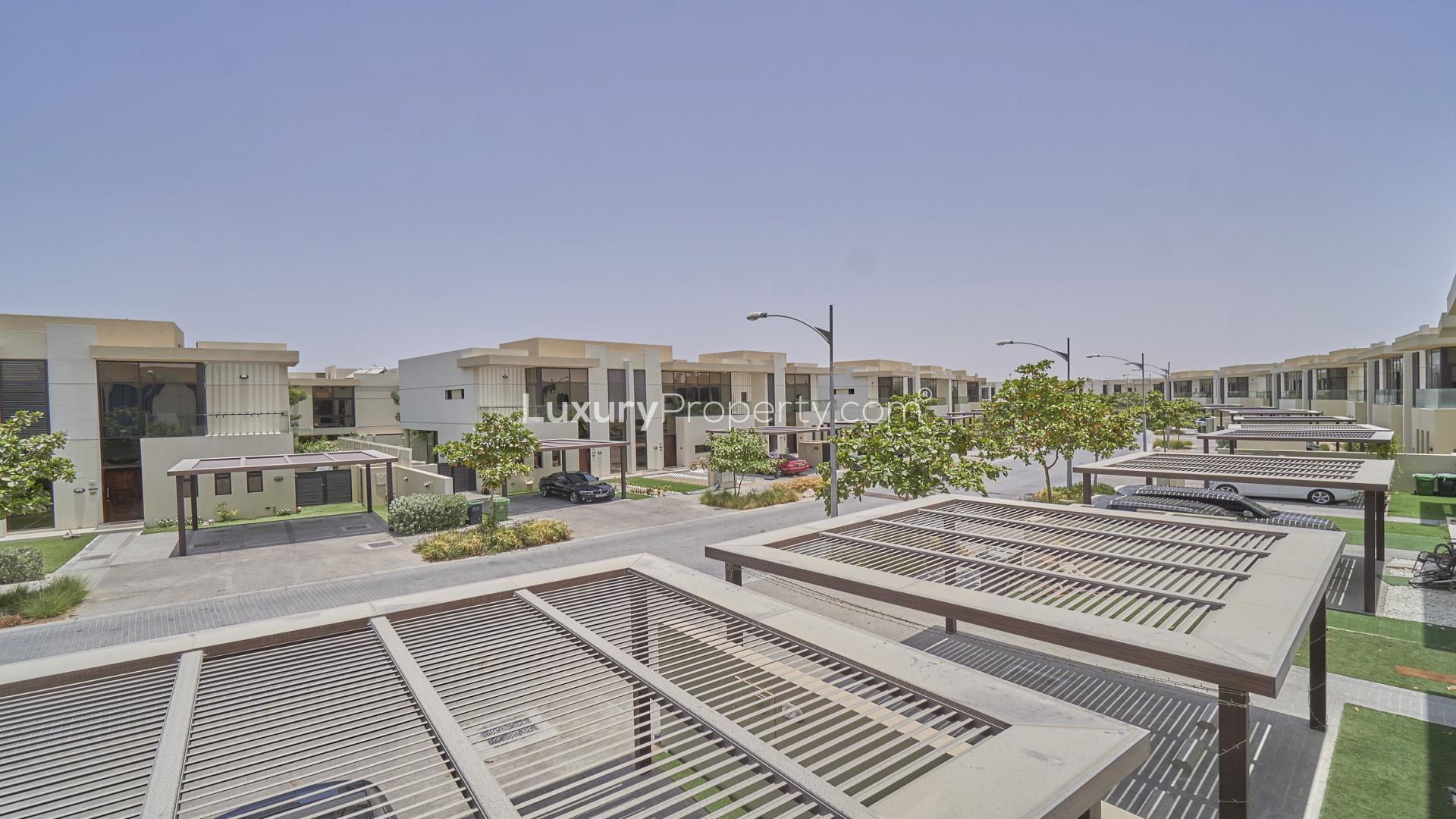 Spacious 3-bedroom villa exterior in Richmond, Damac Hills, with carport and lush greenery