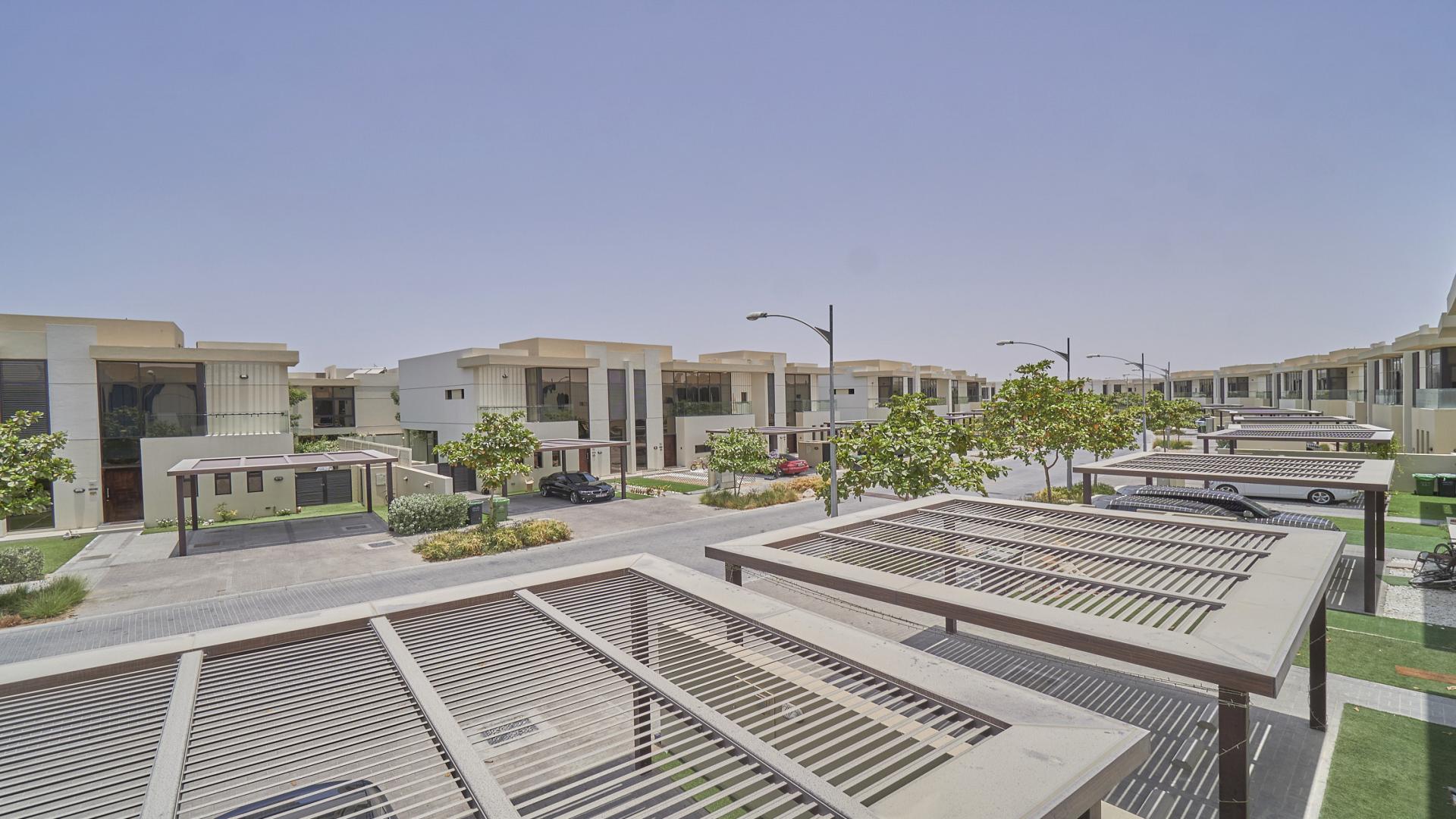 Spacious 3-bedroom villa exterior in Richmond, Damac Hills, with carport and lush greenery