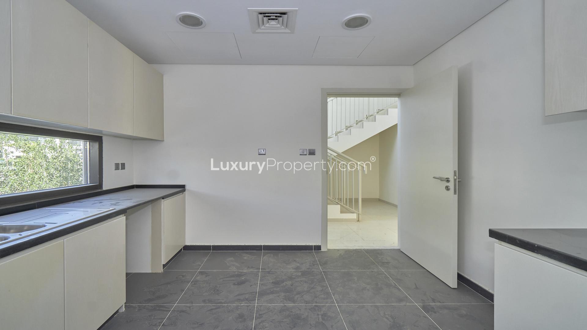 Modern kitchen in Damac Hills villa, Rochester community, with sleek countertops and ample cabinetry