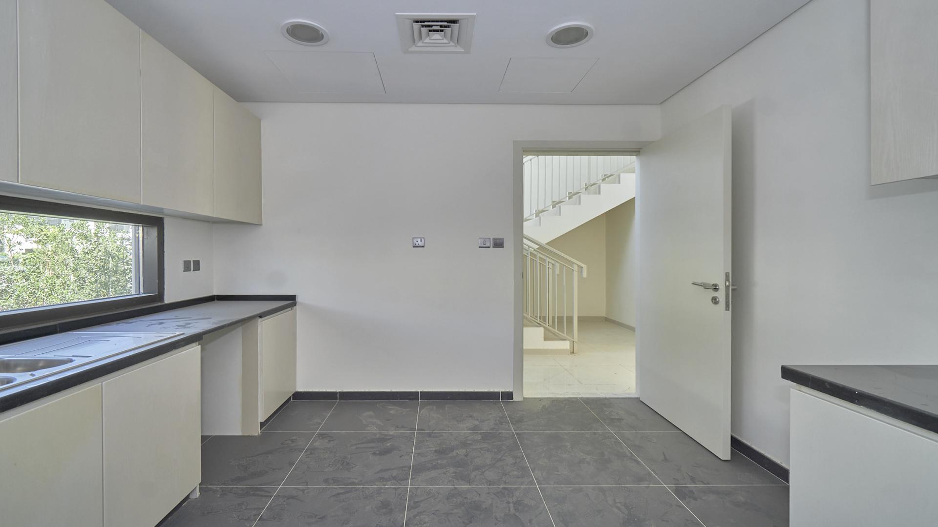 Modern kitchen in Damac Hills villa, Rochester community, with sleek countertops and ample cabinetry