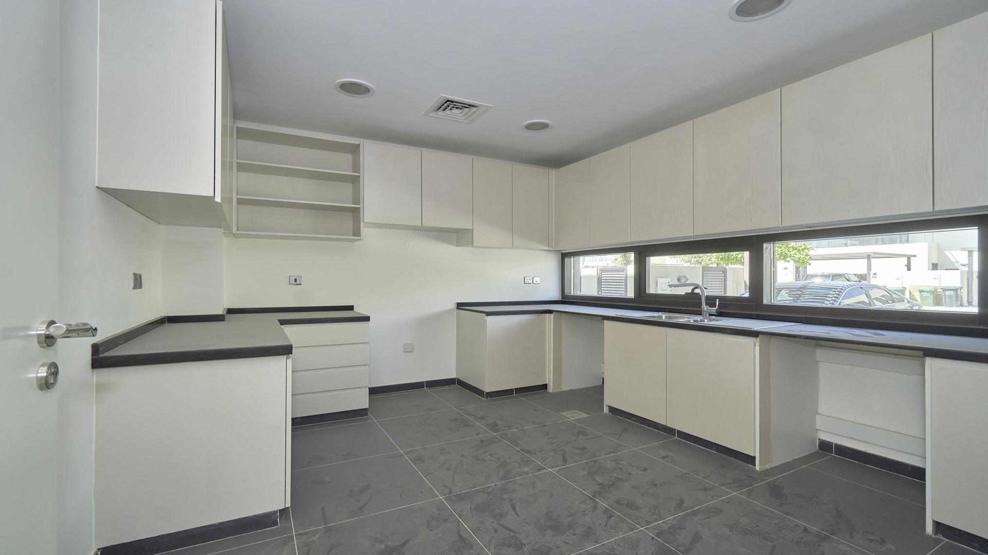 Modern kitchen in Damac Hills villa, Rochester community, featuring sleek cabinetry and countertops