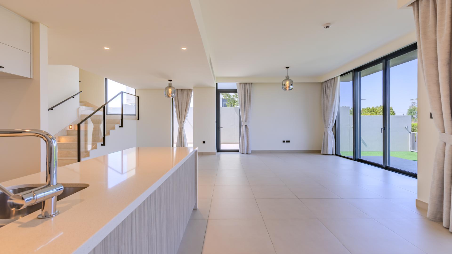 Modern open-plan living area in Golf Grove villa, Dubai Hills Estate, with large windows