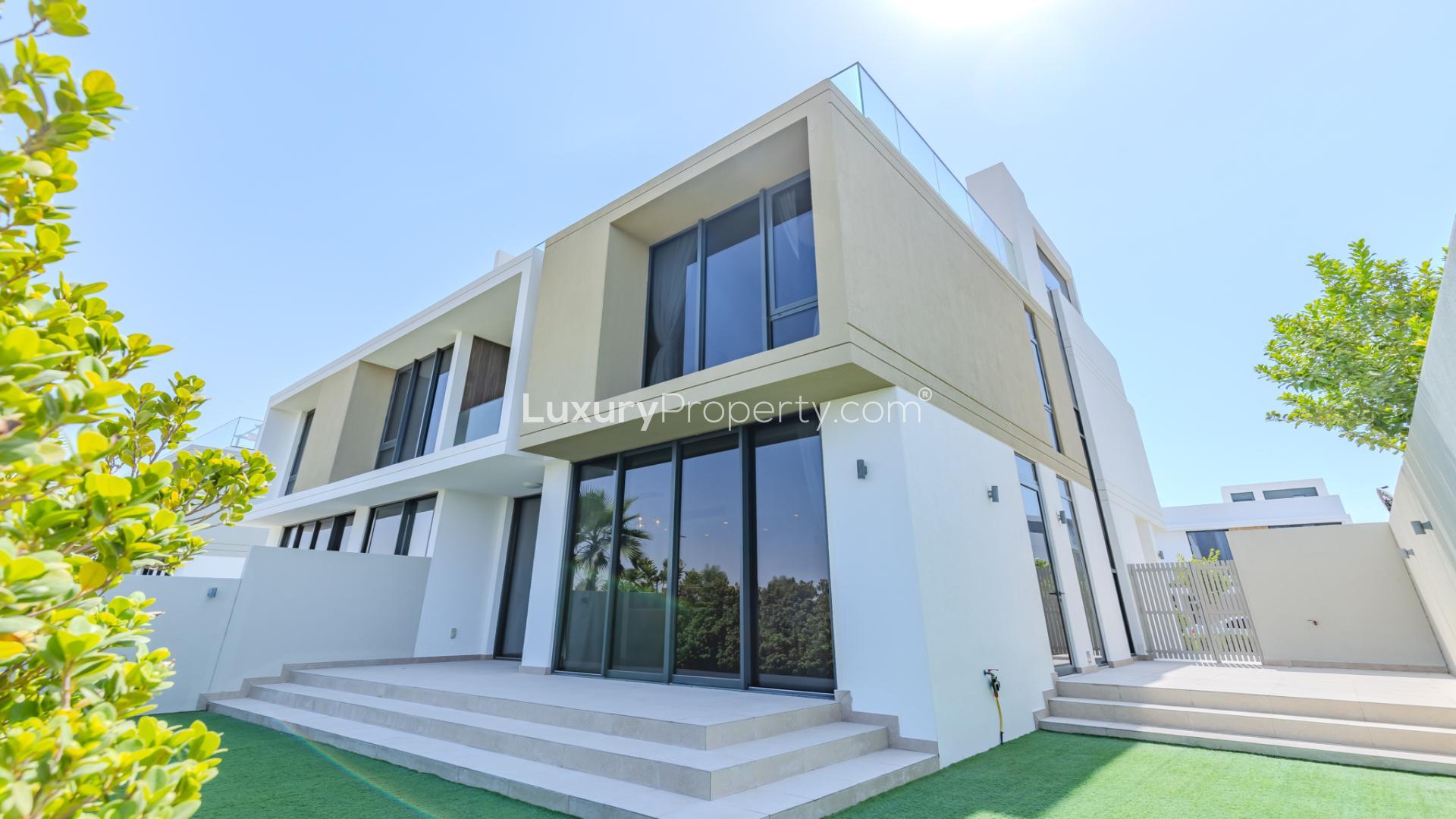 N/A,Modern villa exterior in Golf Grove, Dubai Hills Estate, featuring large windows and green lawn