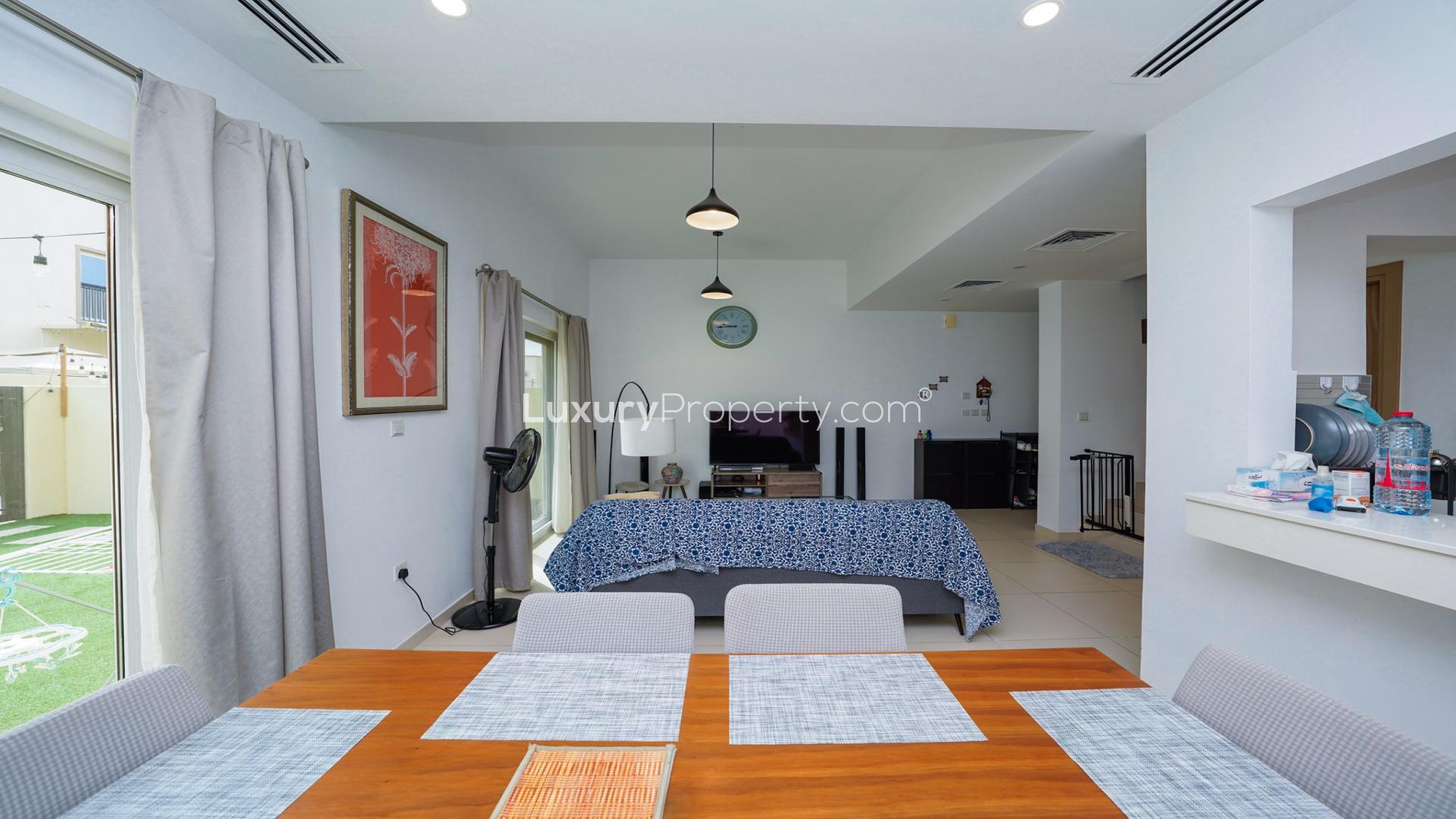 Elegant living room in Villanova villa, Dubai Land, featuring modern decor and garden view