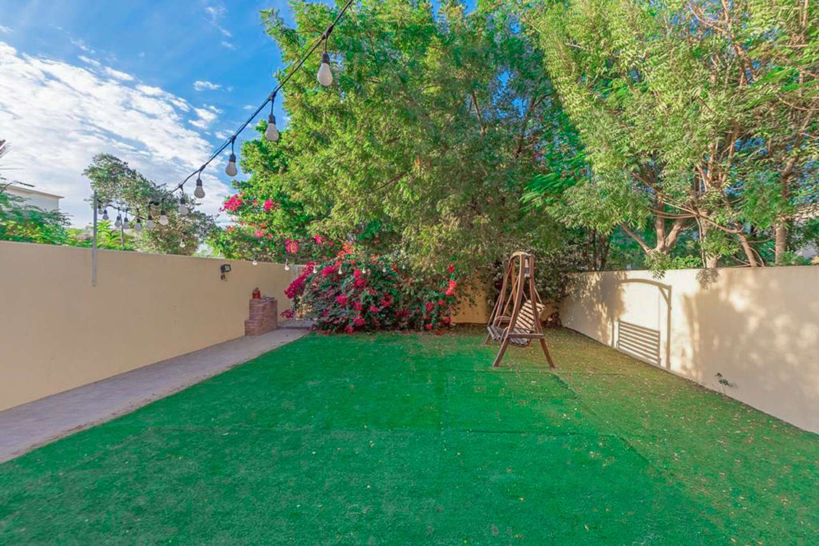 Spacious backyard with swing and greenery at Springs 5 villa, family-friendly rental property