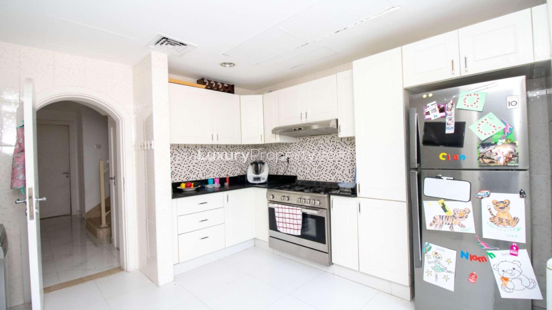 Modern kitchen in 3-bed villa, Springs 14, featuring stainless steel appliances and garden view
