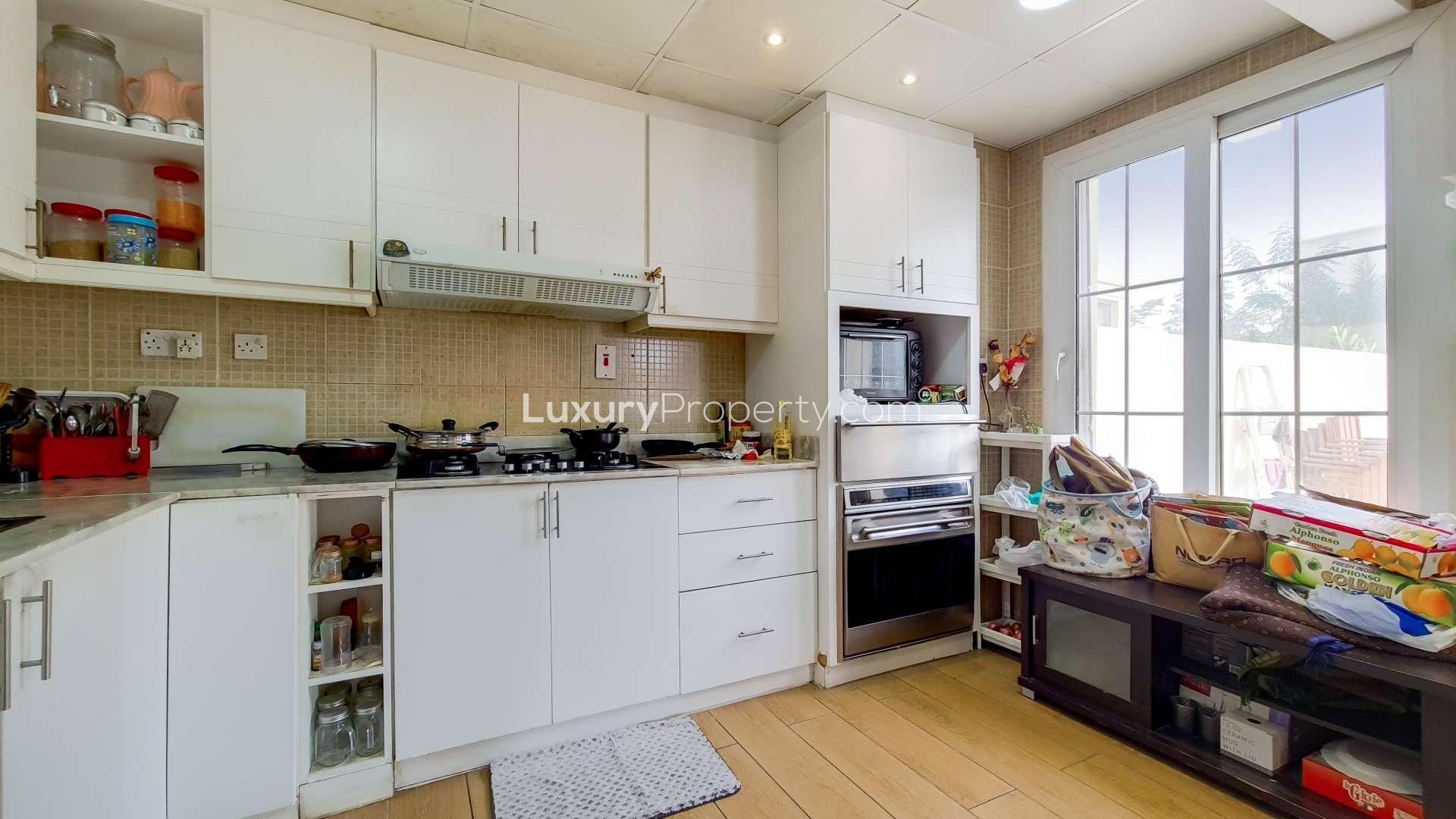 Modern kitchen in fully upgraded villa, Springs 7, with white cabinets and large windows