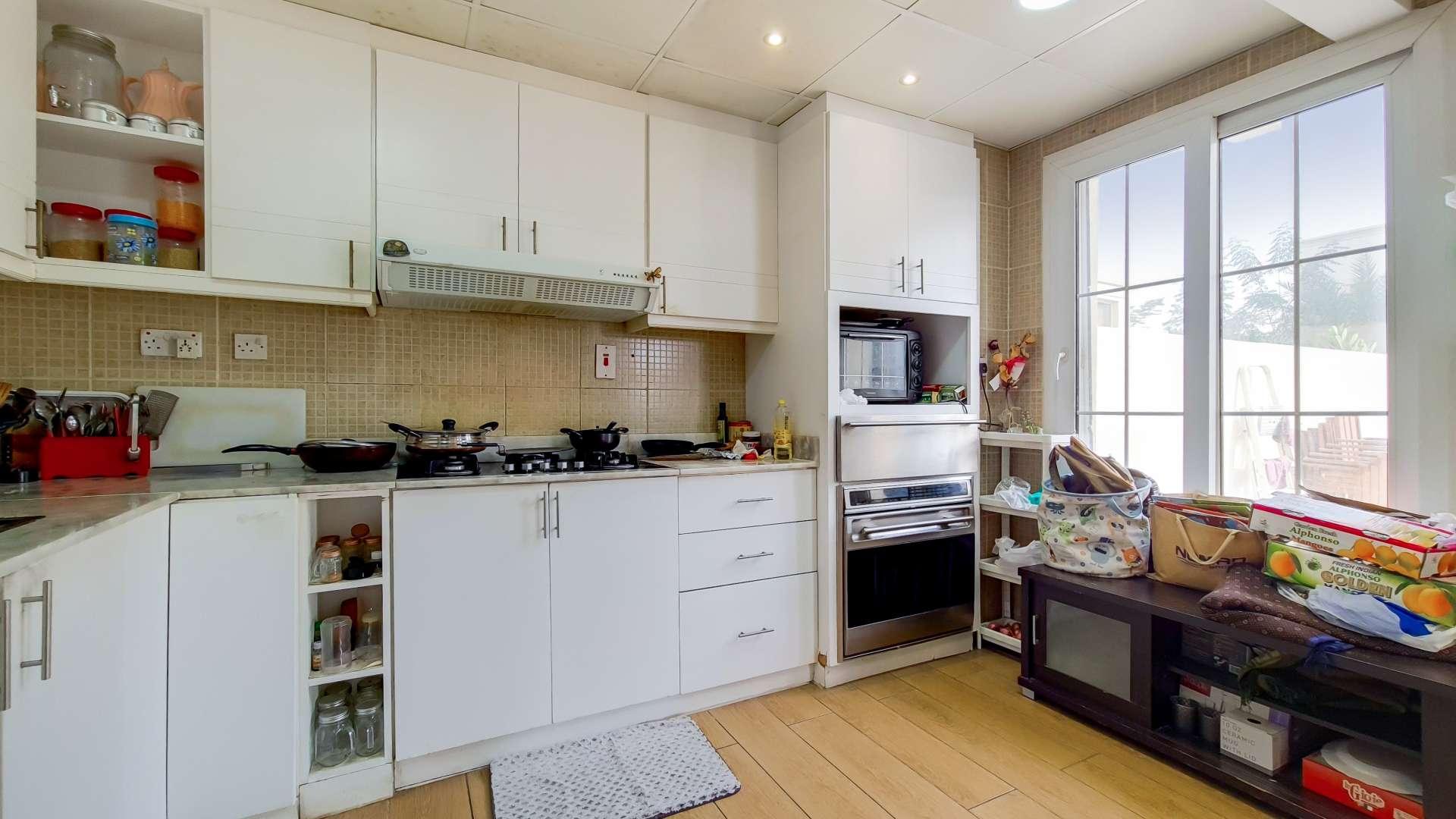 Modern kitchen in fully upgraded villa, Springs 7, with white cabinets and large windows