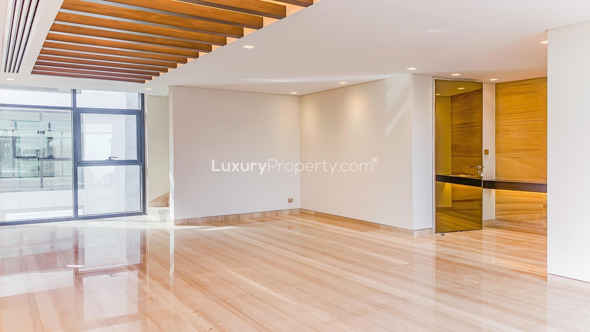 Luxurious villa interior with wooden accents and large windows in Damac Hills, Trevi