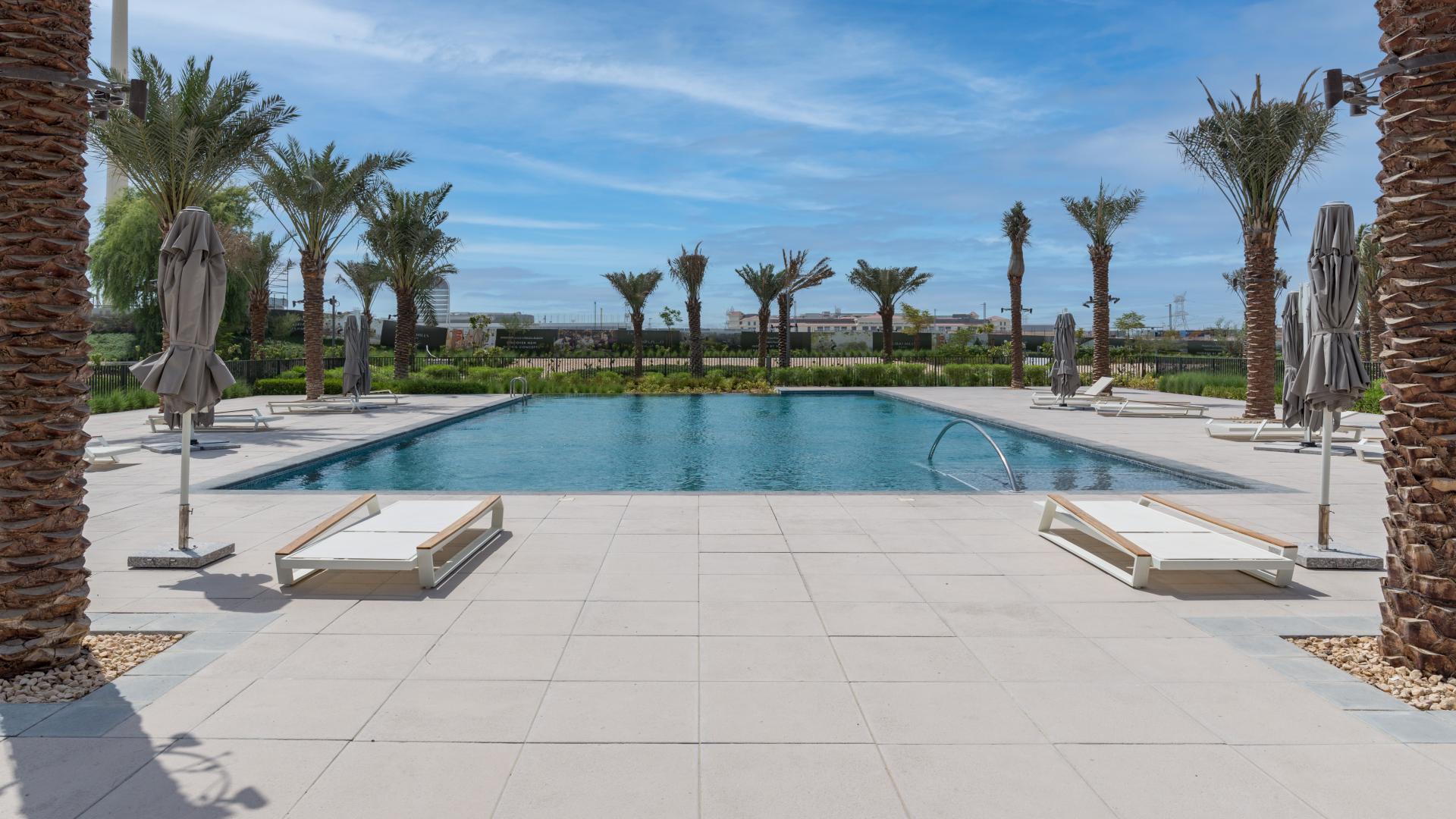 "Spacious villa interior with large windows overlooking golf course, Club Villas, Dubai Hills Estate.",Outdoor pool area at Club Villas, Dubai Hills Estate with palm trees and lounge chairs