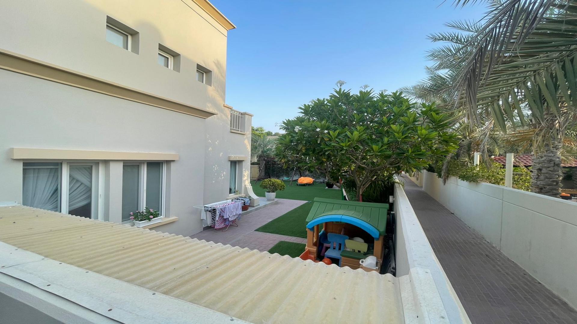 "Elegant villa exterior with driveway in The Springs, Emirates Living, for sale.",Backyard view of 3-bedroom villa in The Springs, Emirates Living, featuring lush greenery
