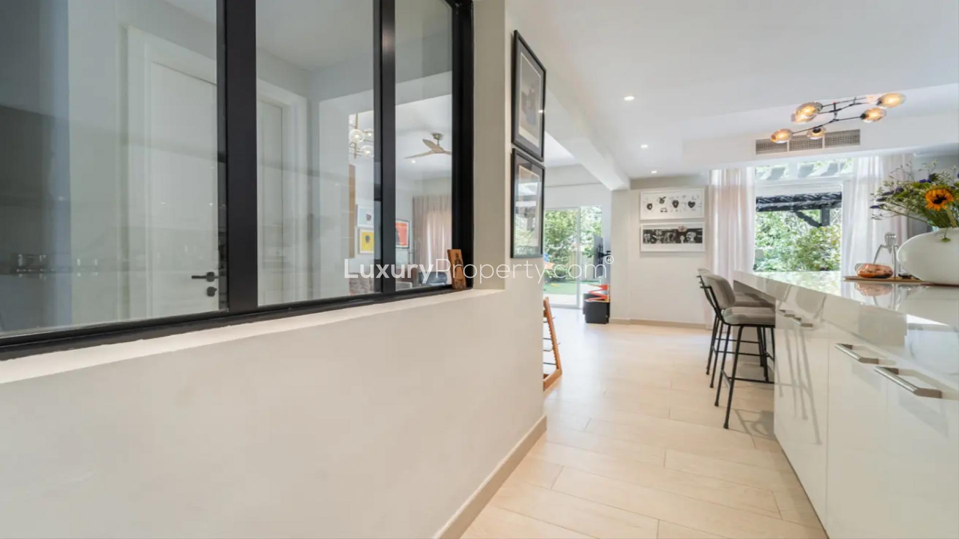 "Modern villa interior with open kitchen and garden view in Springs 15 community.",Modern kitchen interior in renovated villa, Springs 15, featuring sleek design and natural light