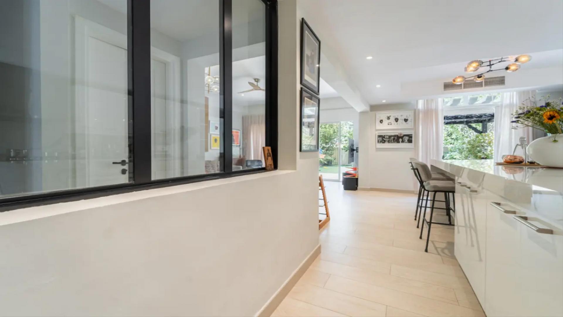 "Modern villa interior with open kitchen and garden view in Springs 15 community.",Modern kitchen interior in renovated villa, Springs 15, featuring sleek design and natural light