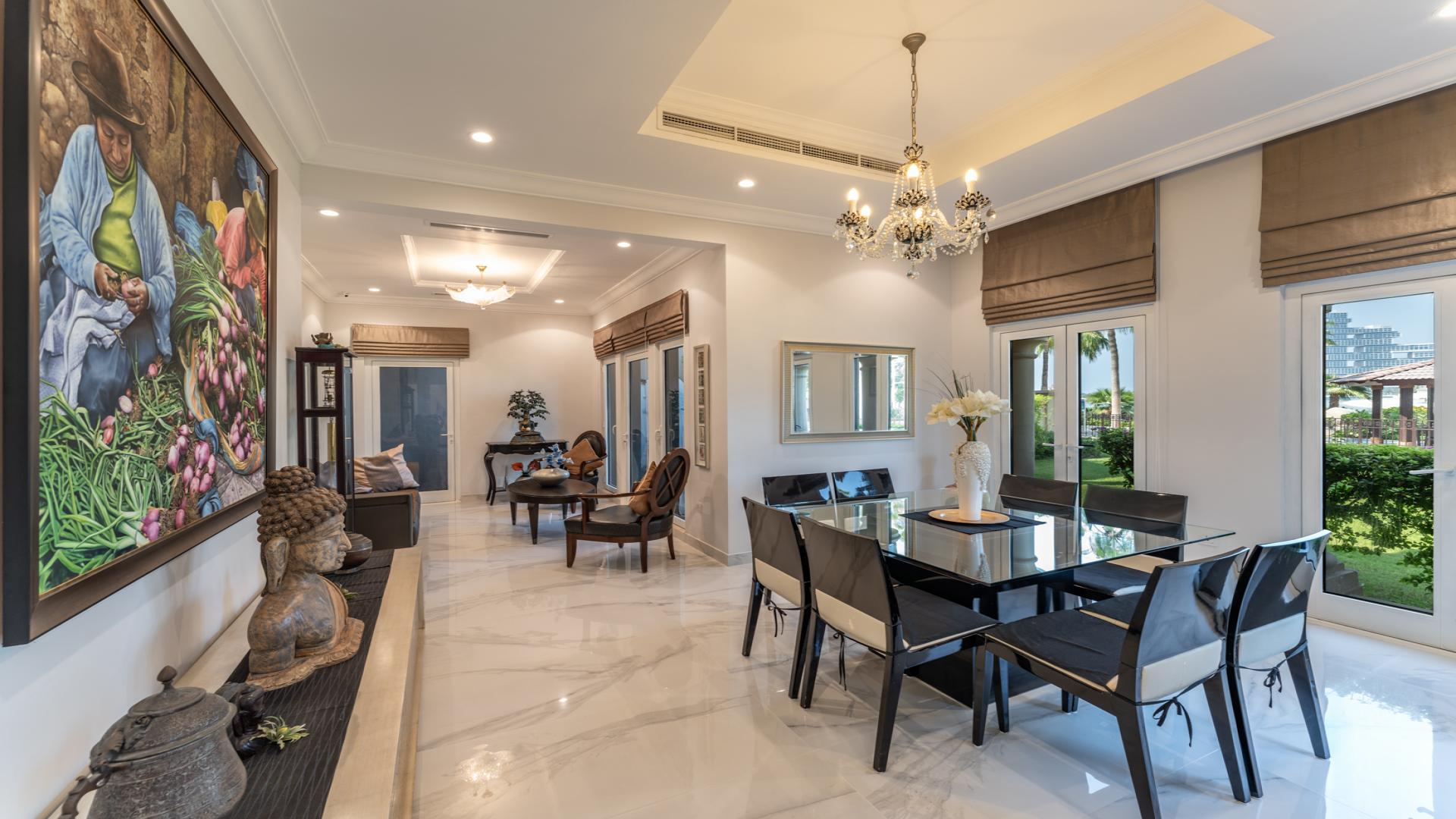 Exterior view of upgraded Canal Cove Villa with lush garden in Palm Jumeirah