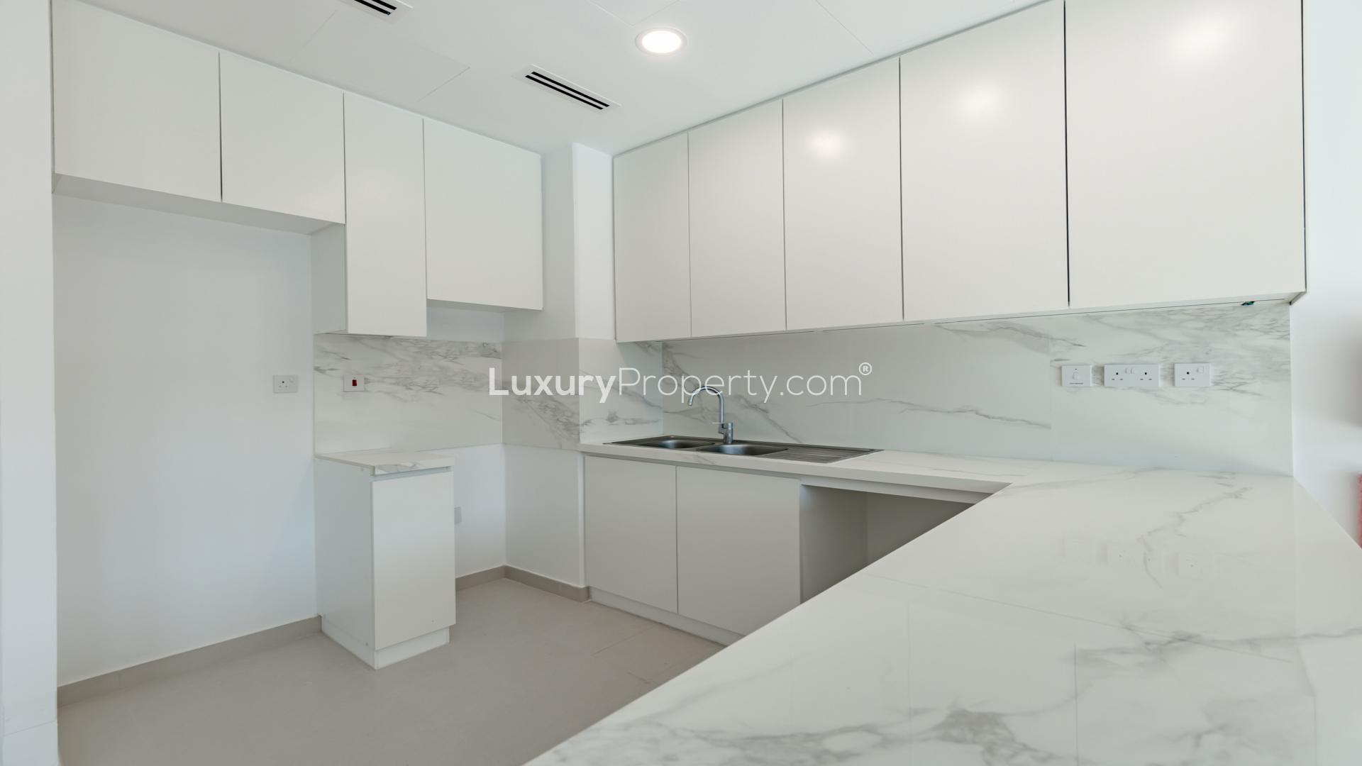 Modern kitchen and living area in Cherrywoods townhouse, Dubai Land. Bright and spacious interior