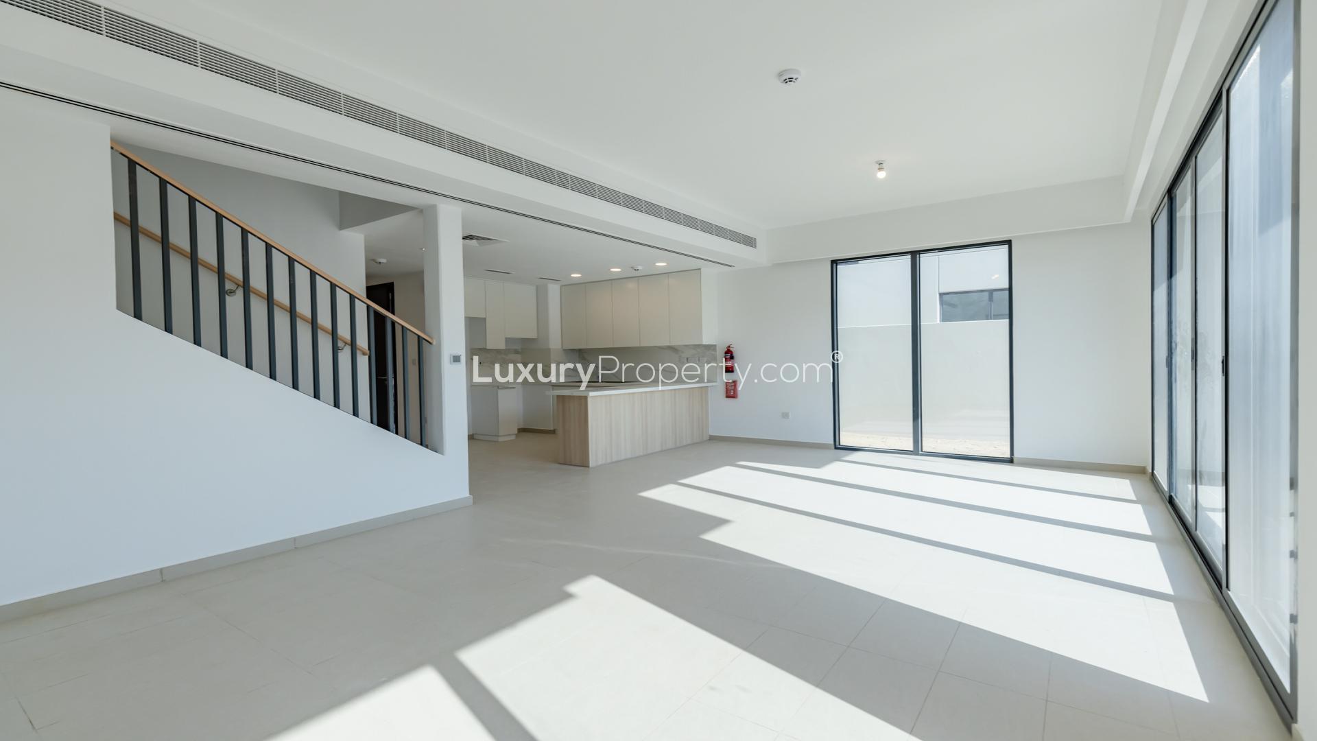 Modern kitchen in 3-bedroom townhouse, Cherrywoods, Dubai Land. Sleek white cabinets and marble countertops