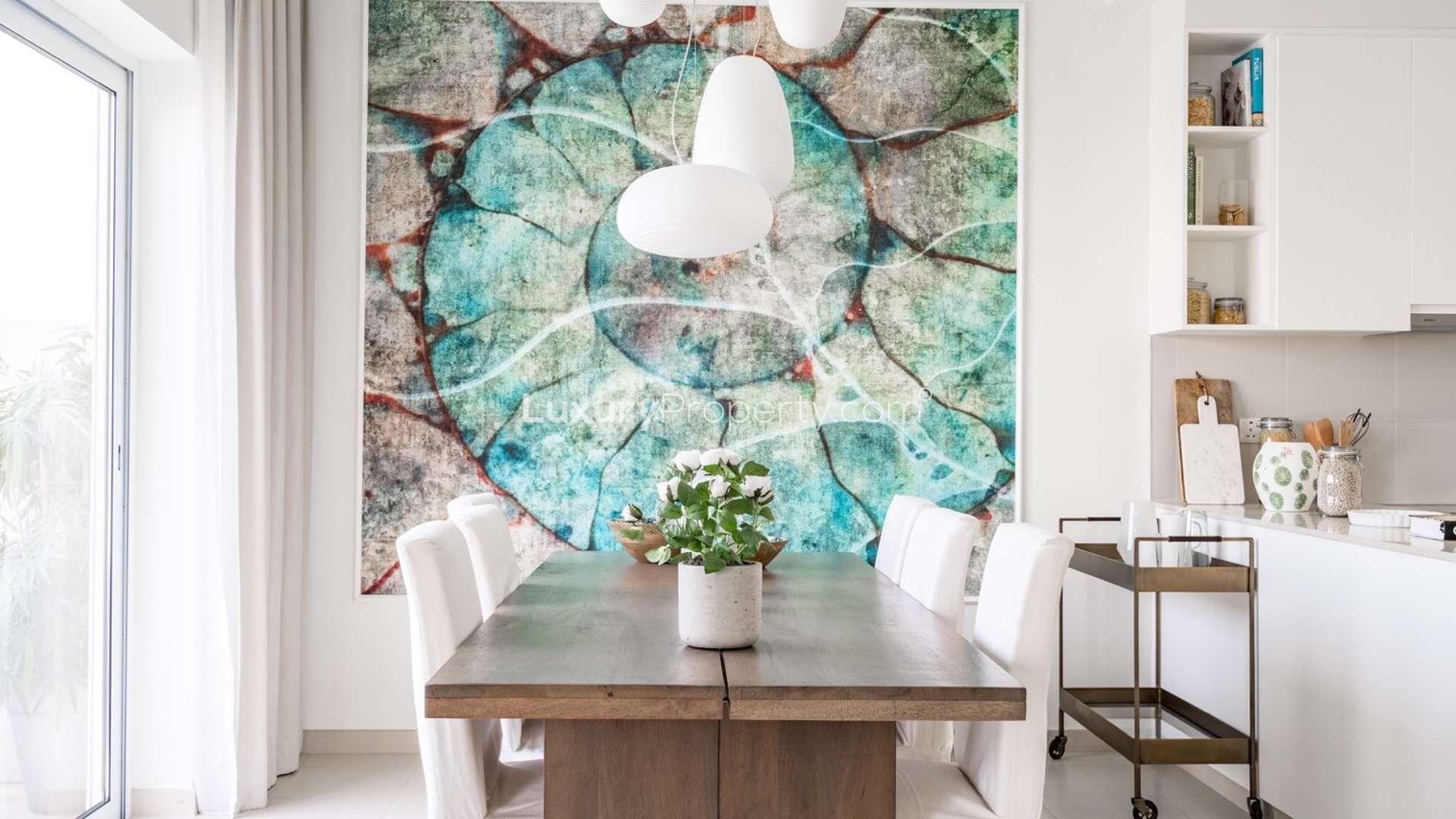 Modern kitchen in charming three-bedroom villa, Emaar South, with sleek white cabinets and appliances