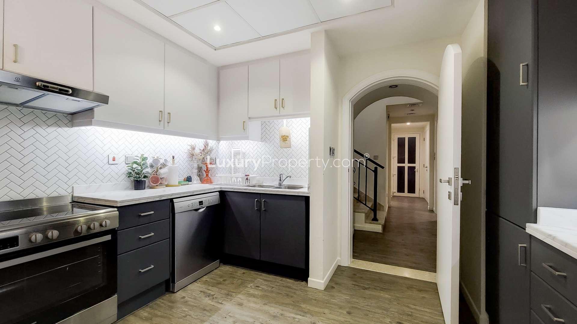 "Spacious living room in upgraded 3-bedroom villa, Ghadeer, The Lakes, LP15399 for sale.",Modern kitchen in upgraded single-row villa, Ghadeer, The Lakes. Spacious and well-lit design