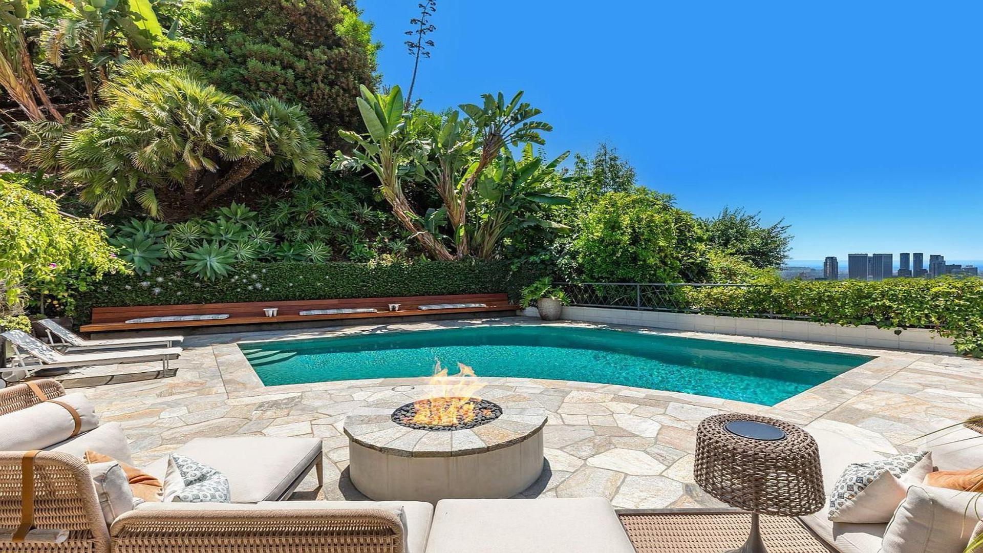 Mid-century villa exterior with lush garden, stone walls, and warm interior lighting, Beverly Hills