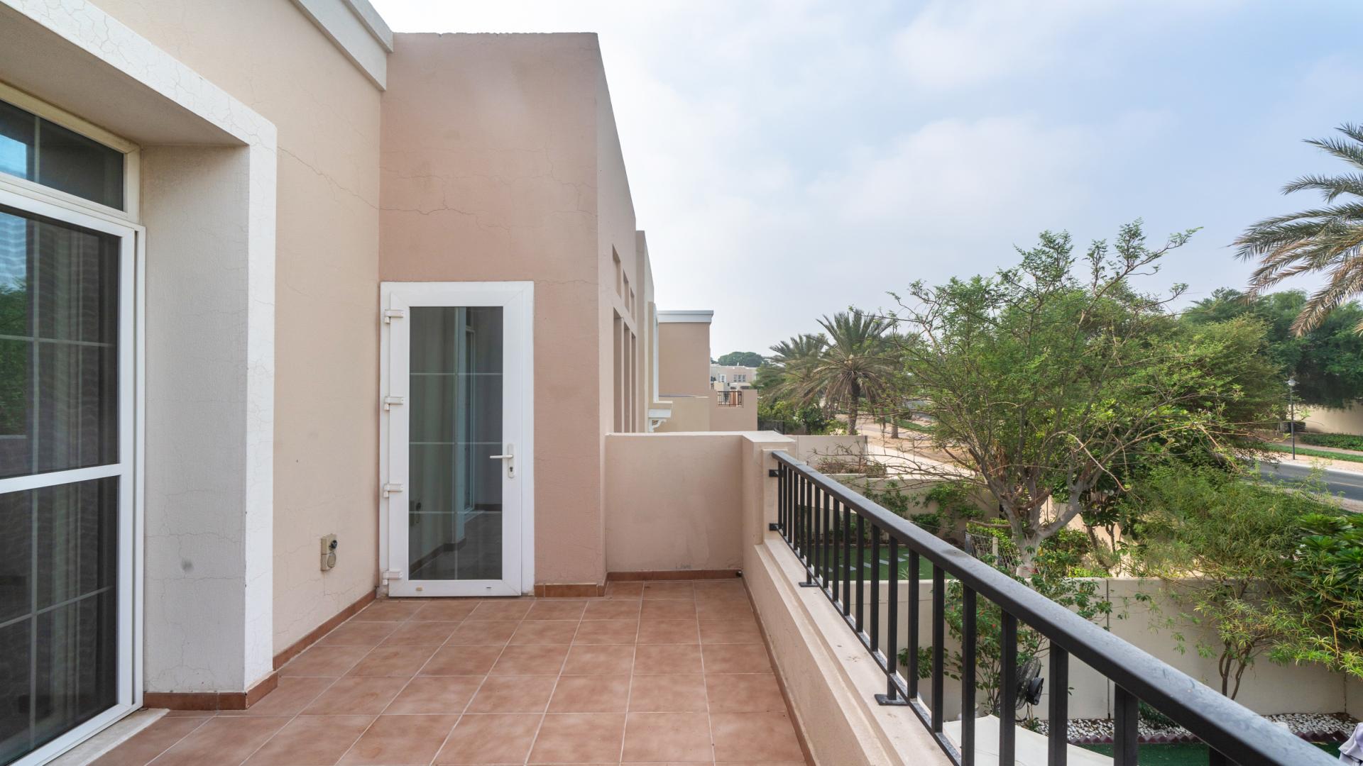 Outdoor patio with dining area in Al Reem villa, Arabian Ranches, lush greenery surrounds
