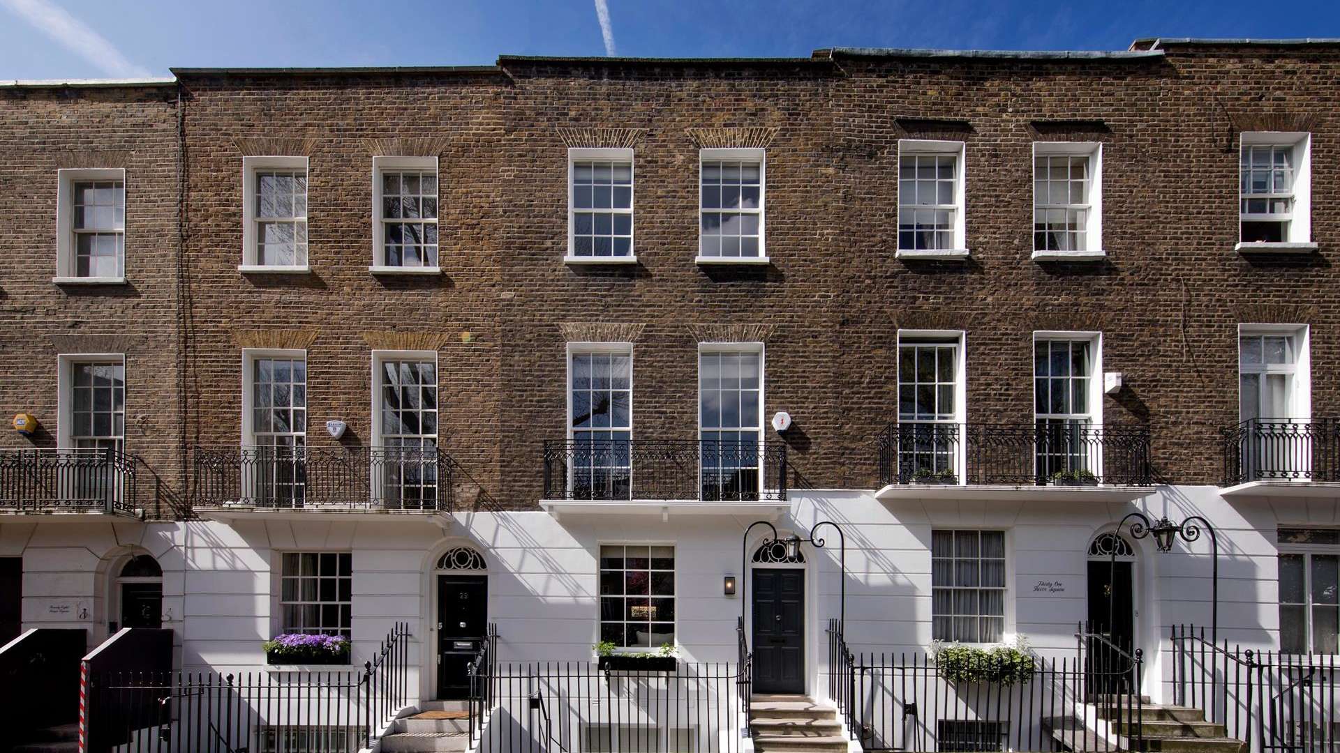 Private courtyard of a 3-bedroom villa in Knightsbridge, London, with brick walls and greenery