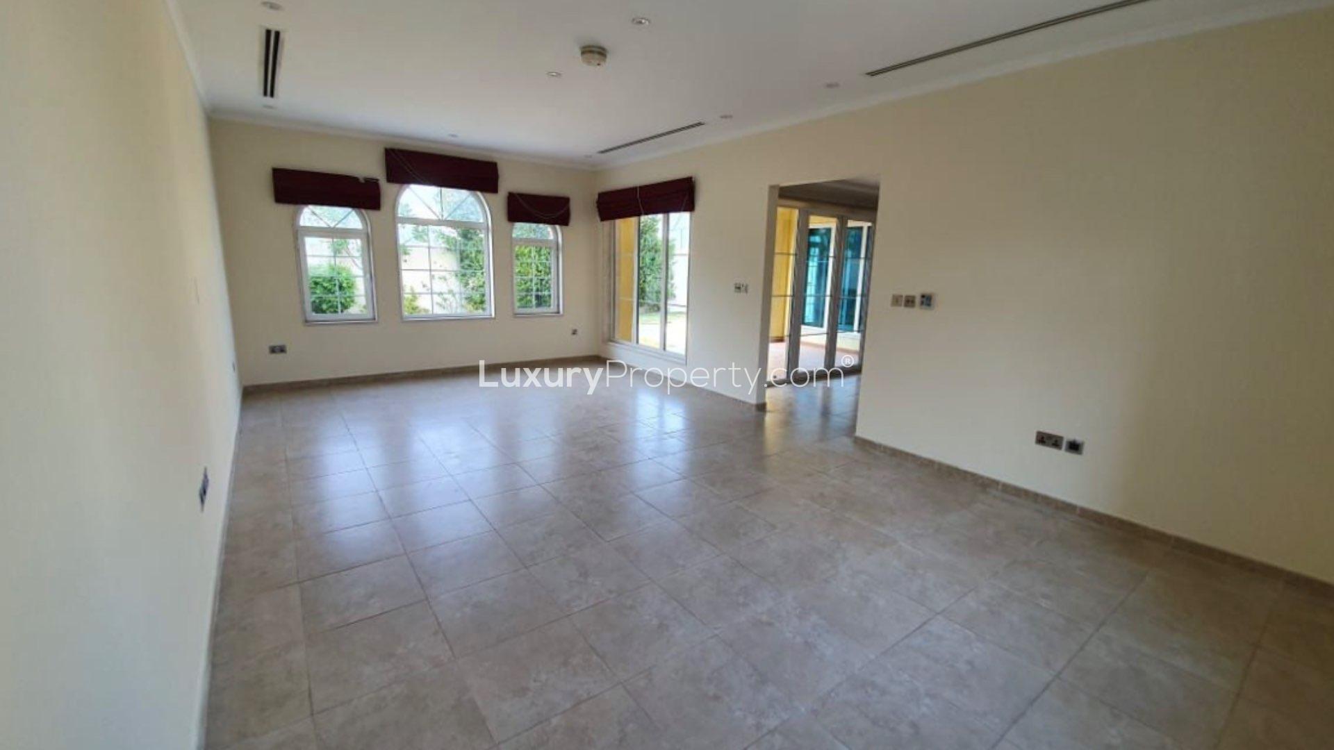 "Charming 3-bedroom villa on corner plot in Jumeirah Park Legacy, for sale.",Spacious living room in Jumeirah Park villa for sale, featuring large windows and tile flooring