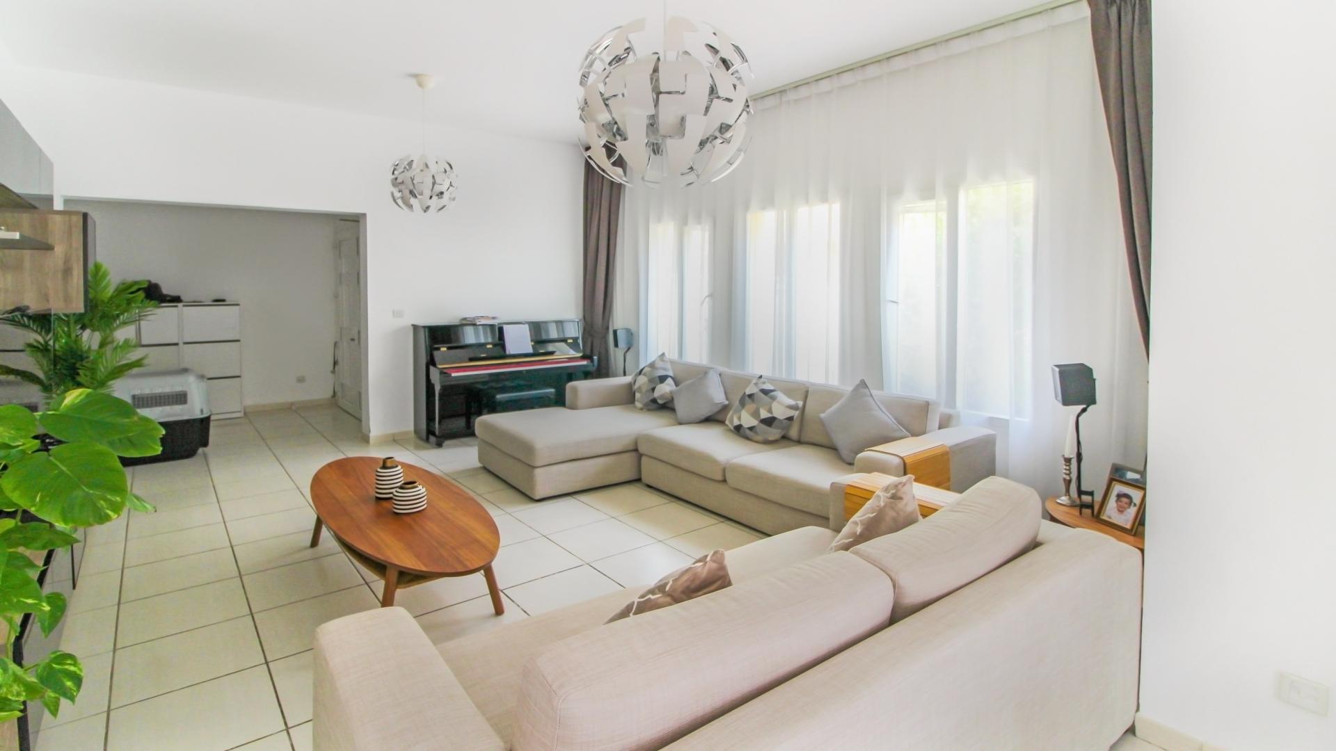 Living room in Maeen villa, The Lakes, with modern decor and ample natural light