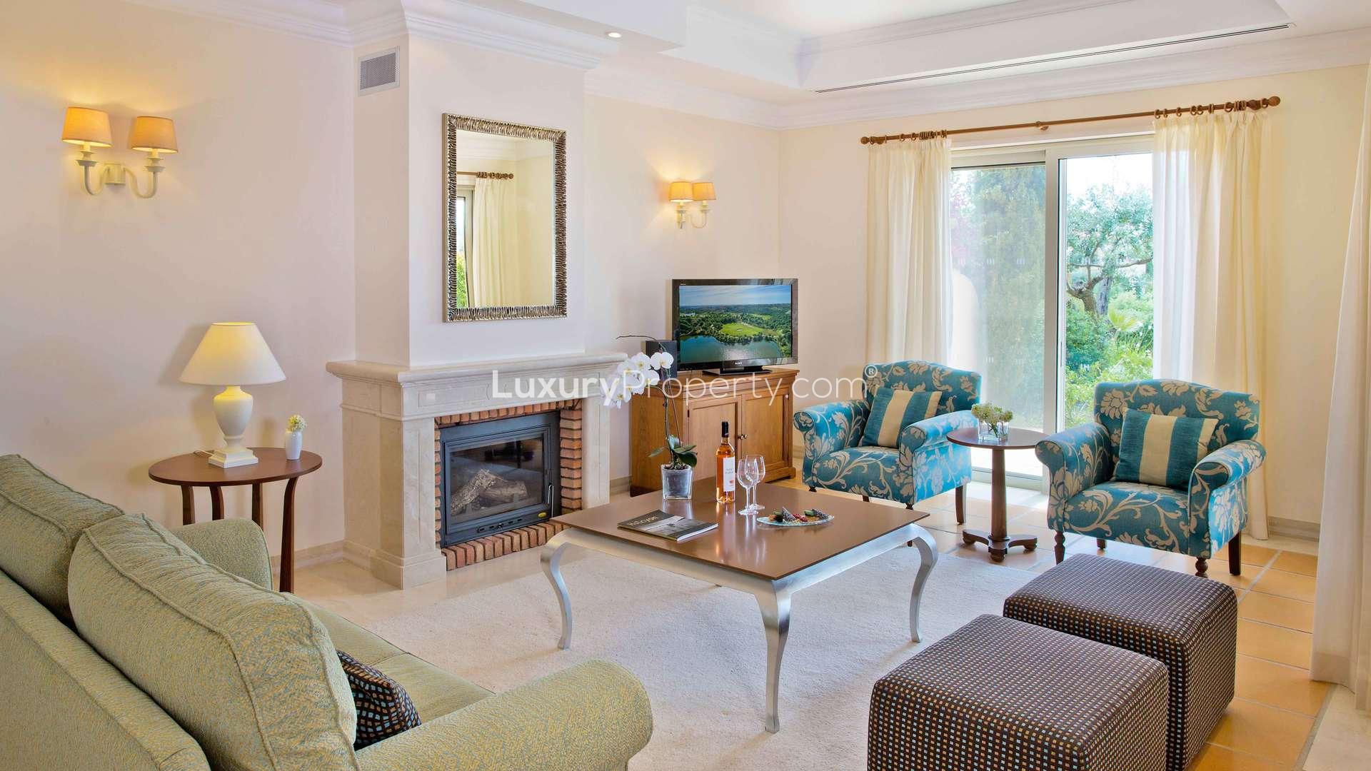 "Fully upgraded three-bedroom villa exterior in Monte Rei, Algarve, Portugal, with lush garden.",Luxurious living room in upgraded three-bedroom villa, Monte Rei, Algarve, Portugal for sale