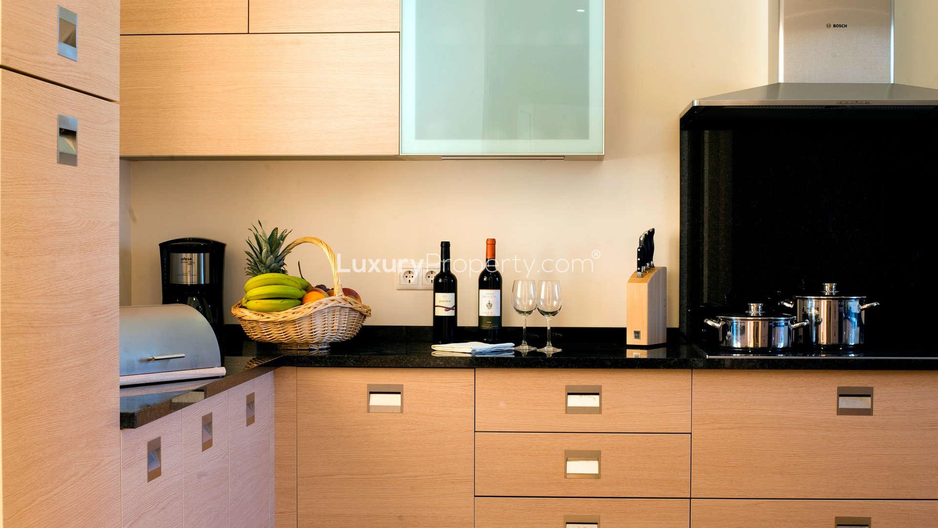 Modern kitchen in upgraded three-bedroom villa, Monte Rei, Algarve, featuring sleek cabinetry and appliances