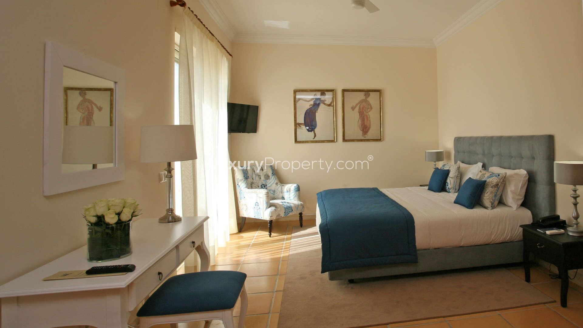 Luxurious bedroom in Monte Rei villa, Algarve, with balcony view and elegant decor