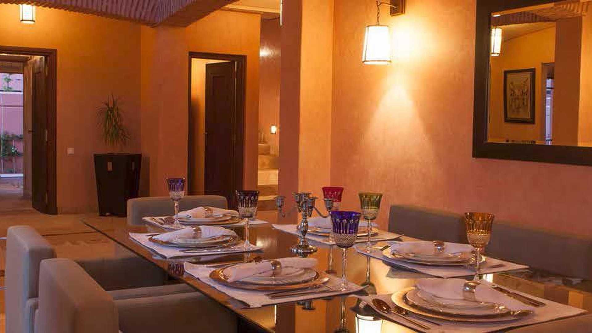 Elegant outdoor seating area with palm trees at Hattan Villa, Amelkis Resort, Marrakech