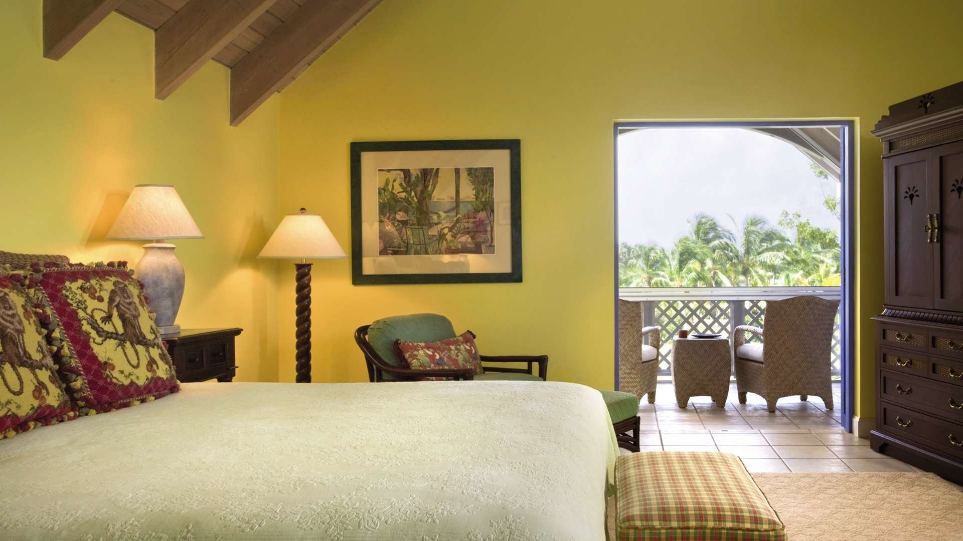 "Charming villa exterior with lush greenery in Nevis Estate Villas, St. Kitts & Nevis.","Bright bedroom with balcony view in Nevis Estate Villas, St. Kitts & Nevis.",Bright living room with wicker chair and lamp in Nevis Estate Villas, St. Kitts & Nevis.