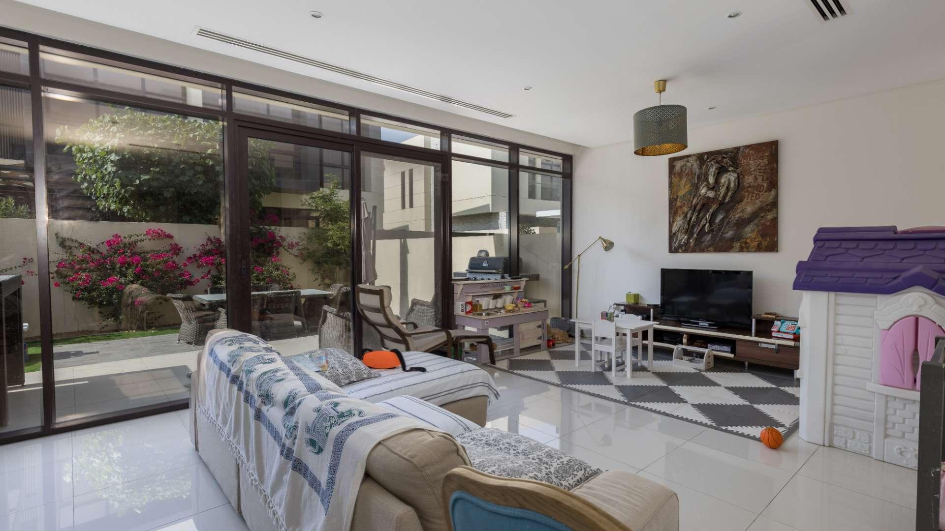 Contemporary 3-bedroom villa exterior in Queens Meadow, DAMAC Hills, with driveway and palm trees