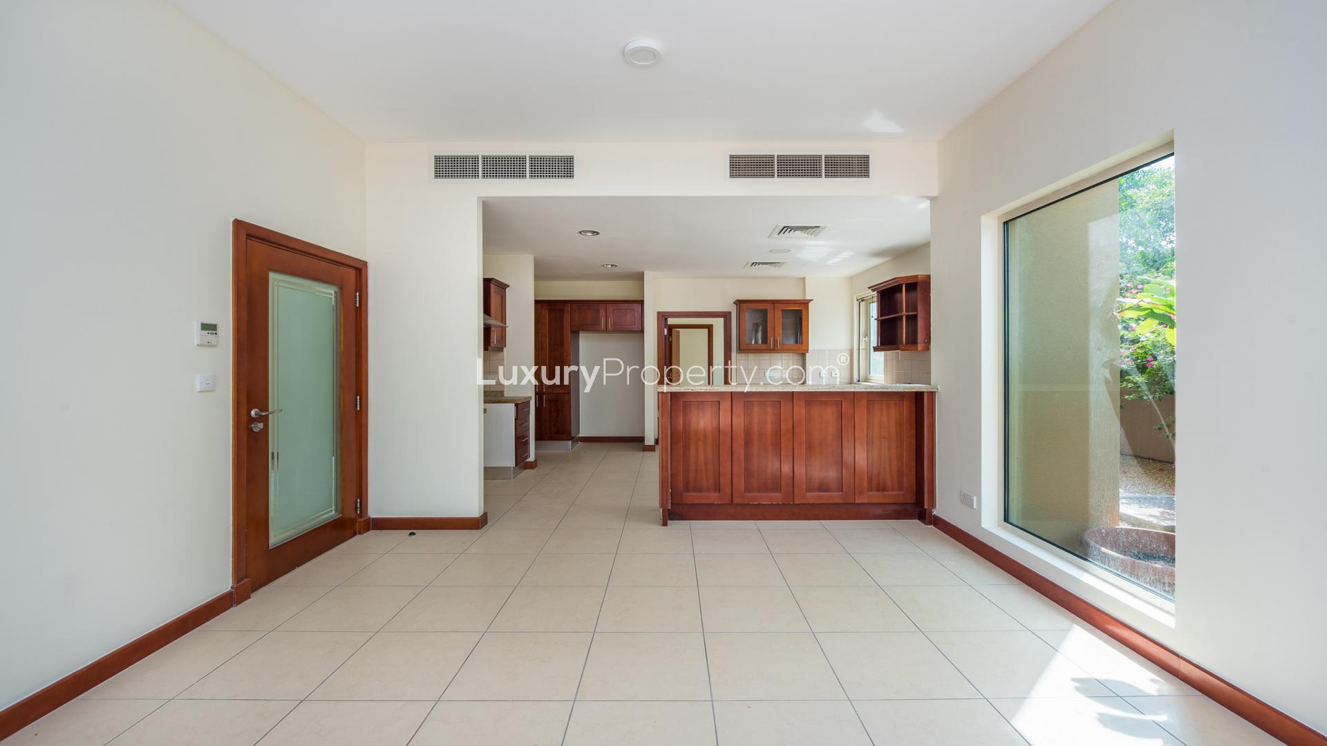 Interior view of spacious living area in Saheel villa, Arabian Ranches, with garden access
