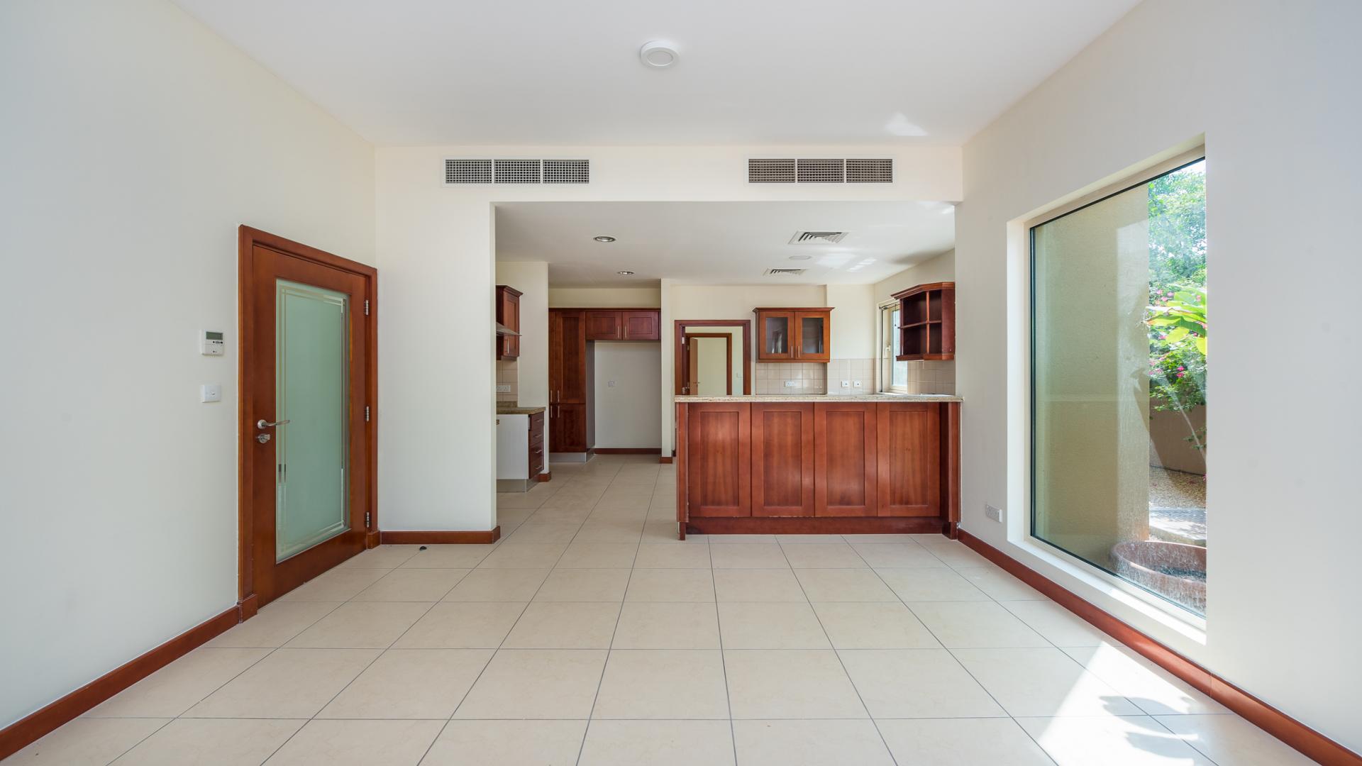 Interior view of spacious living area in Saheel villa, Arabian Ranches, with garden access