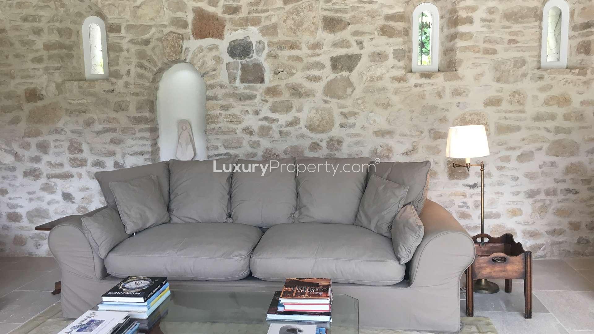 Elegant living room in St. Tropez villa with stone walls and modern decor