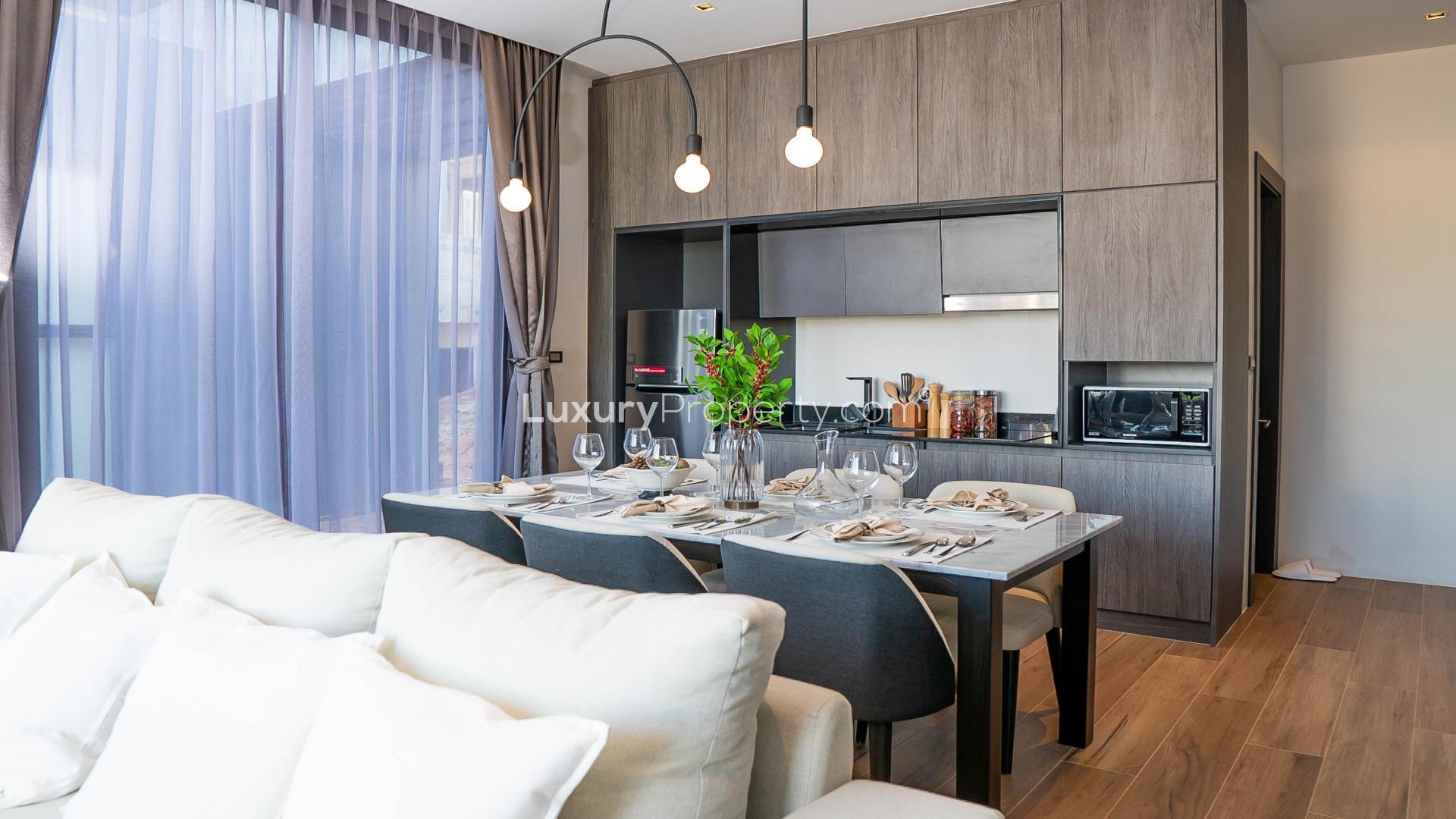 Modern living room in Phuket villa with elegant decor and open kitchen layout