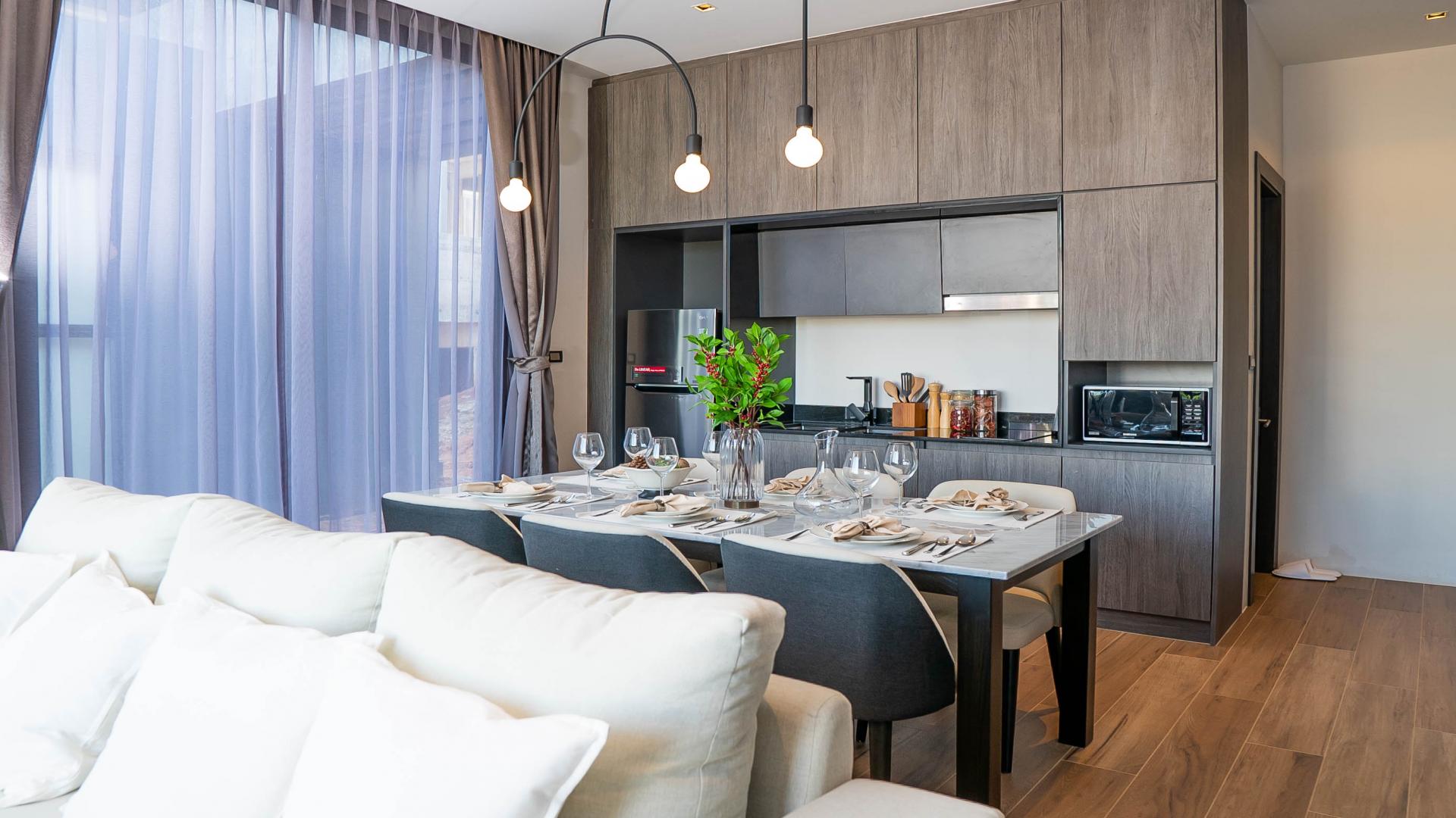 Modern living room in Phuket villa with elegant decor and open kitchen layout