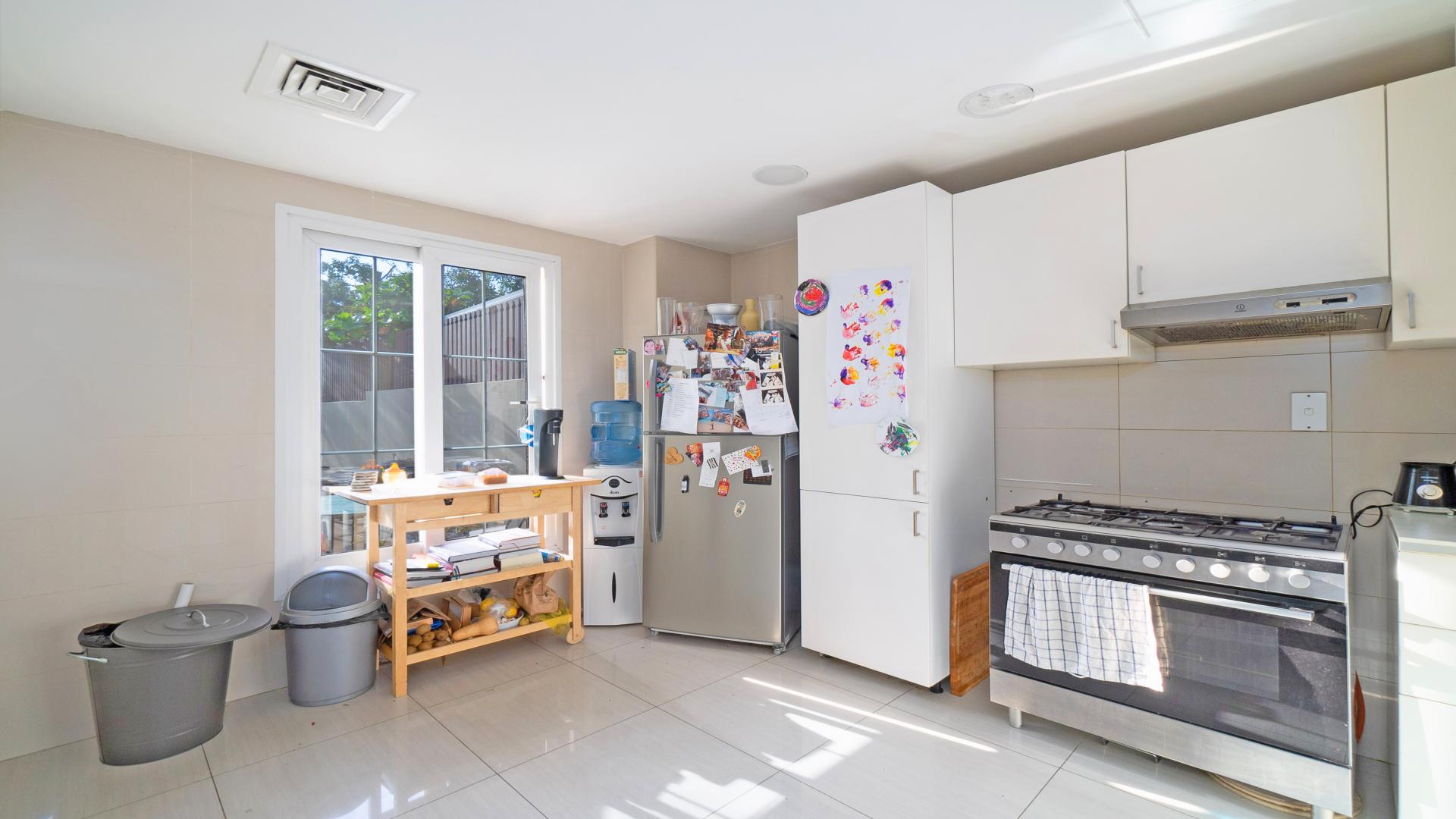 Spacious backyard of 3-bedroom villa in The Springs, featuring lush greenery and seating area