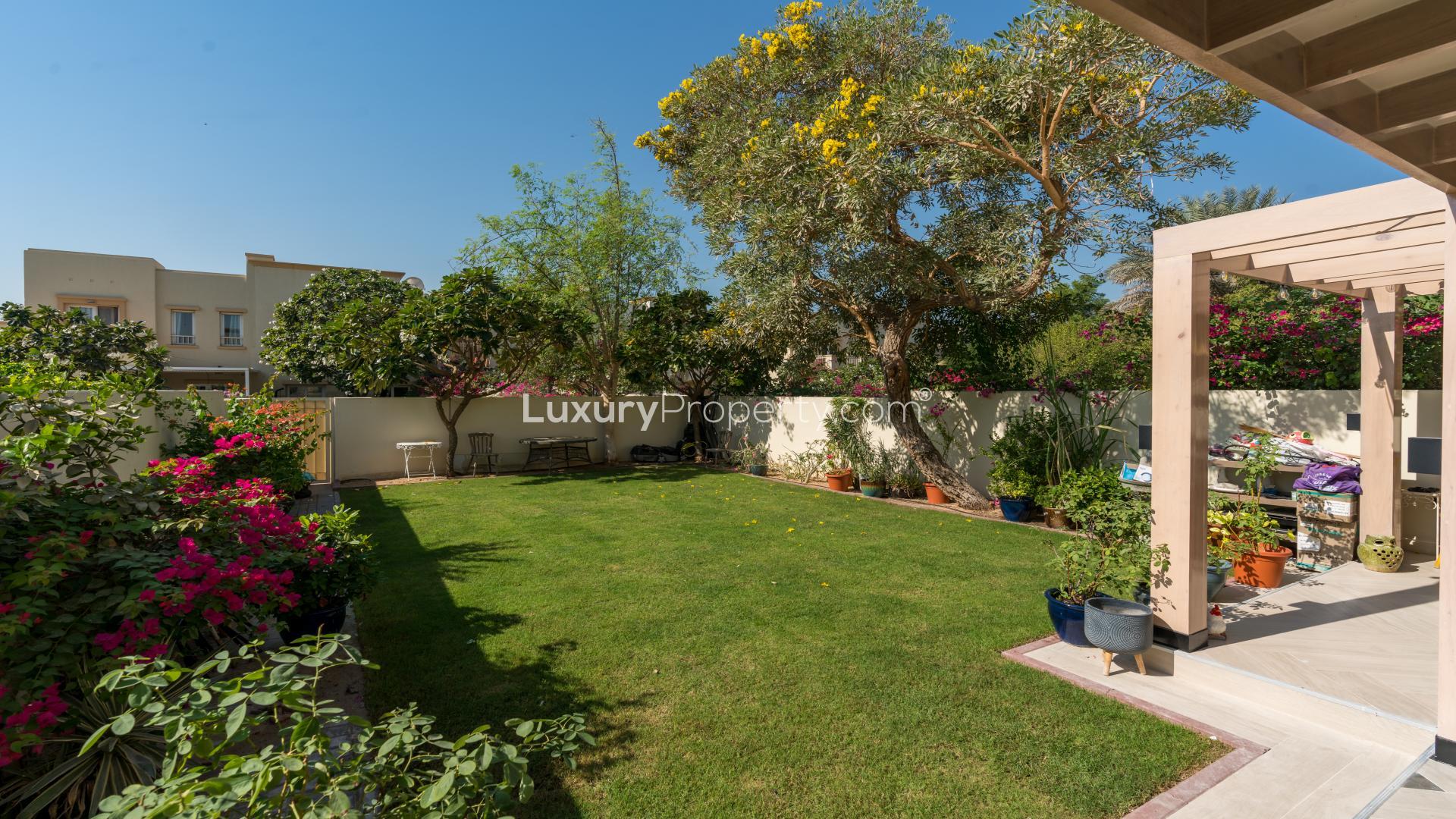 Living room of upgraded villa in The Springs with garden view through sliding doors