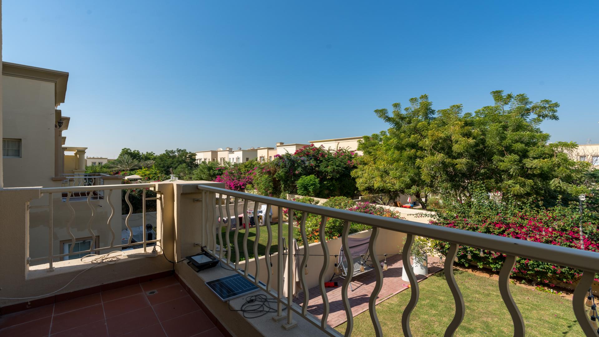 "View from villa balcony overlooking manicured garden in Springs 11 community, Dubai.",Dining area in Springs 11 villa with garden view, featuring modern decor and natural light