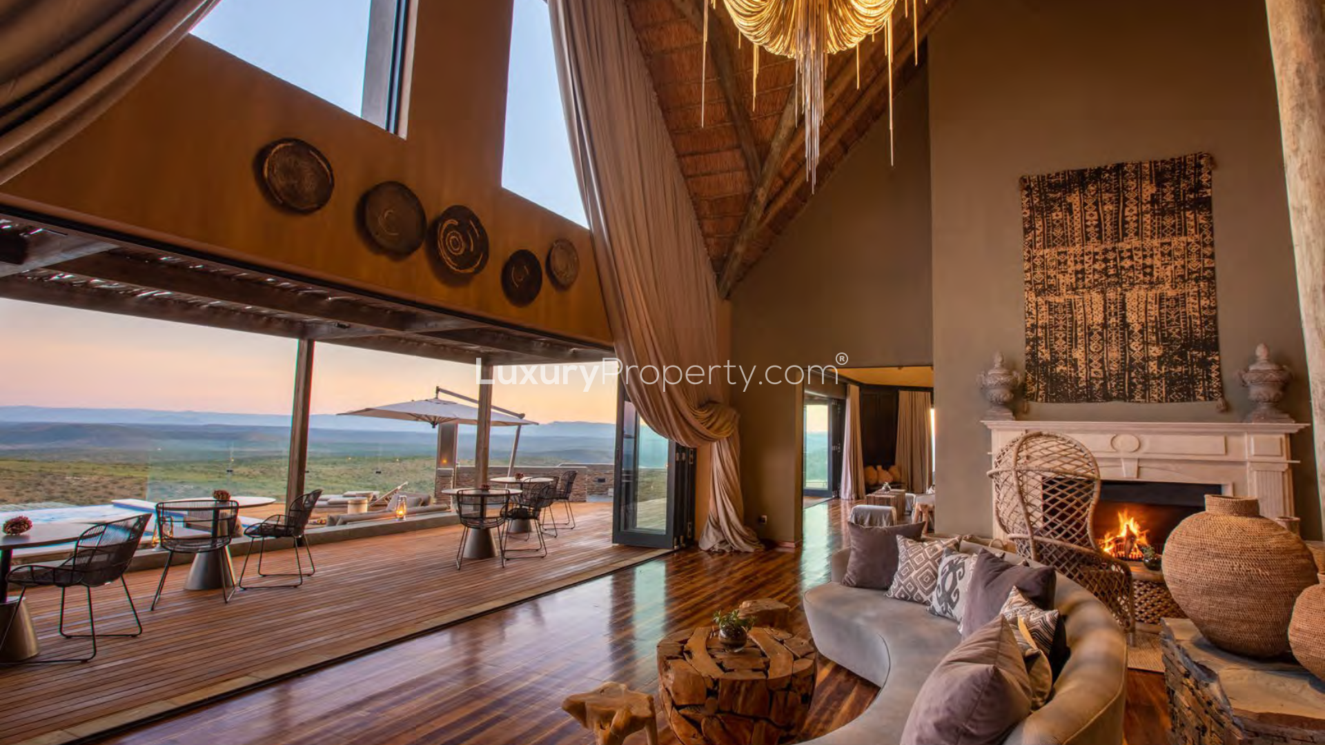 Luxurious living room in South Africa villa with fireplace, leather sofas, and rustic decor