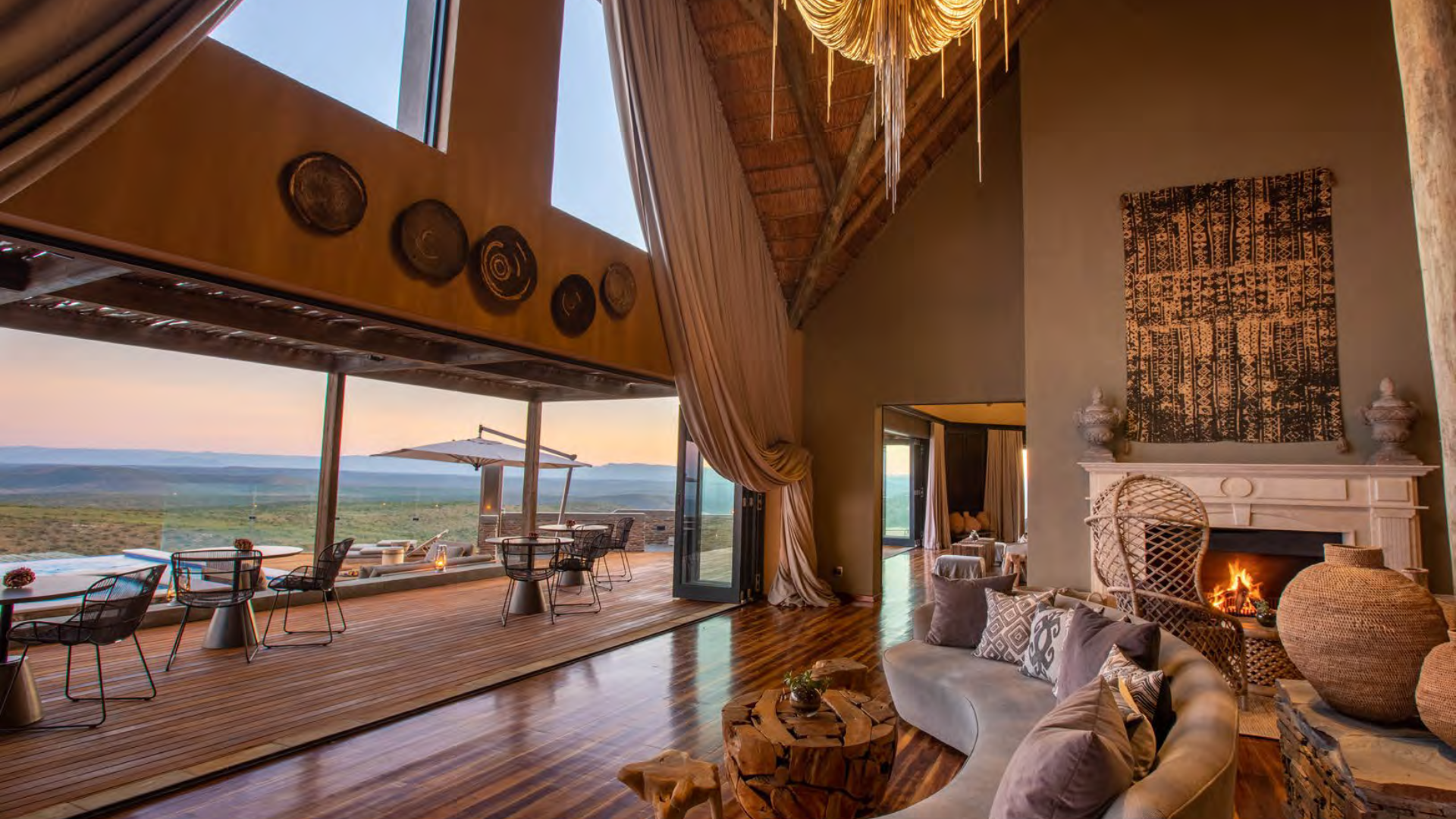 Luxurious living room in South Africa villa with fireplace, leather sofas, and rustic decor