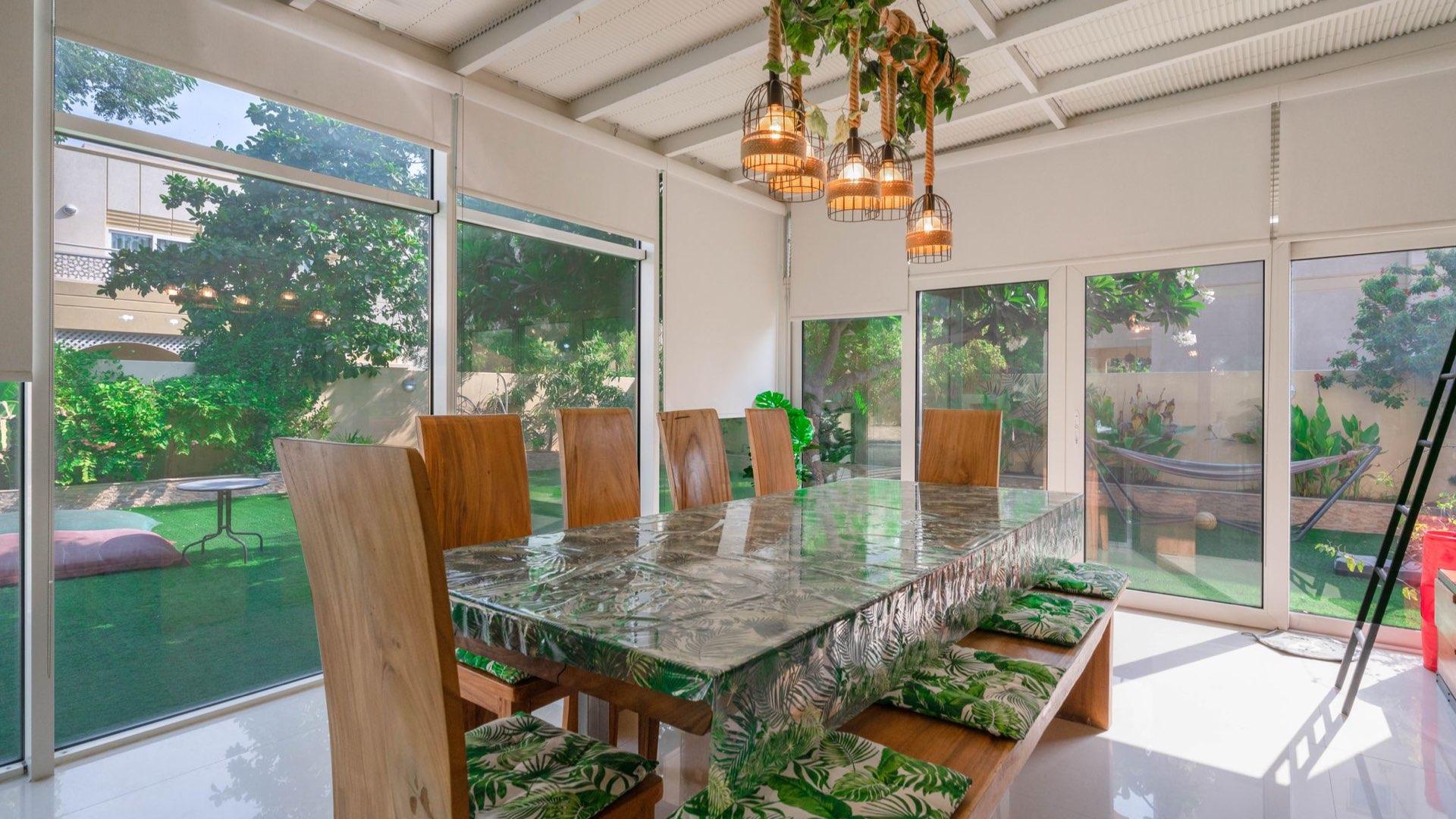 Living room with modern decor in Meadows 9 villa, featuring large window view of garden