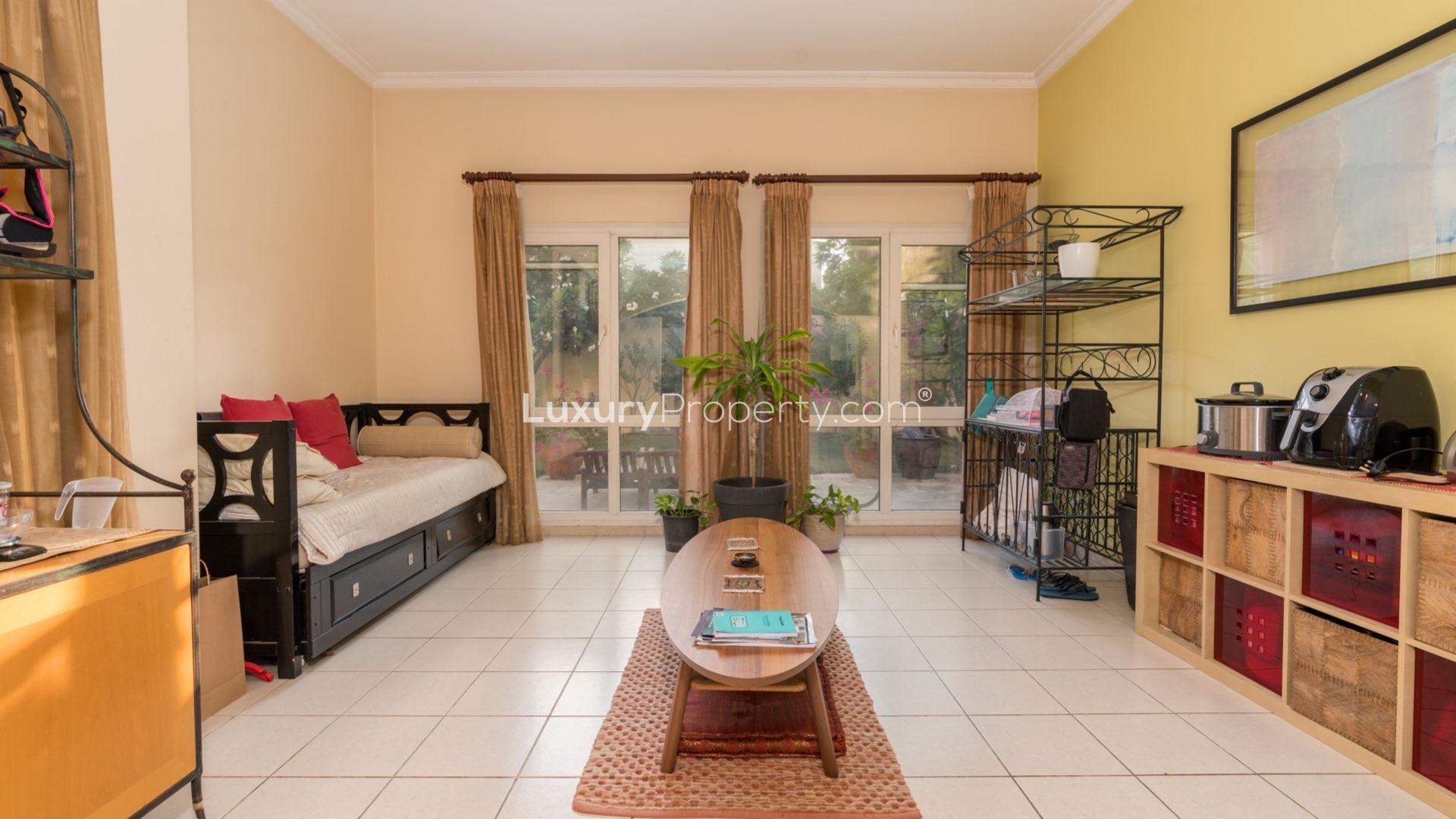 "View from family villa balcony in Meadows 9, Emirates Living with lush greenery.",Spacious living area in family villa, Meadows 9, Emirates Living, with garden view