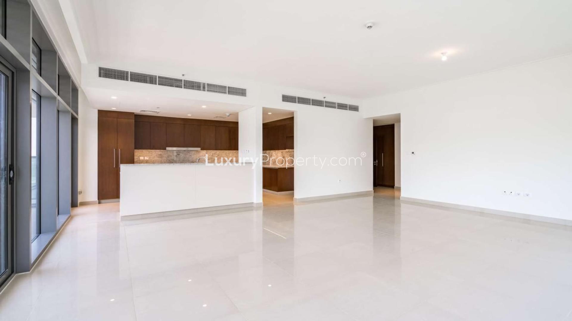 "Scenic view of lush park near Mulberry apartment, Dubai Hills Estate, Park Heights community.",Modern open-plan kitchen and living area in Mulberry duplex, Dubai Hills Estate apartment