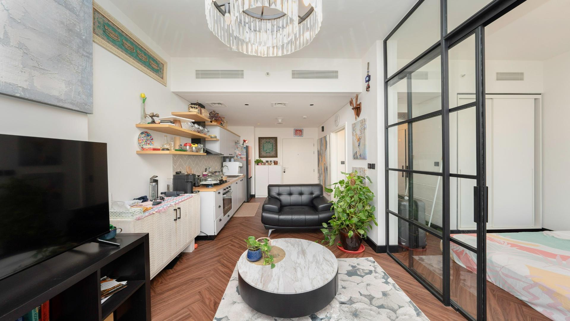 Modern living area in Dubai Hills Estate apartment, featuring stylish decor and open kitchen