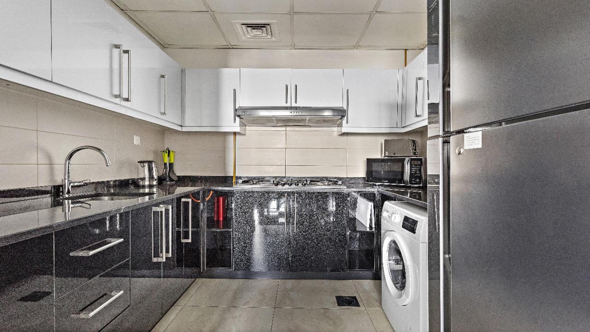 "Spacious living room in high-floor 4-bedroom apartment, Business Bay, Elite Residence, modern decor.",Modern kitchen in 4-bedroom apartment, Business Bay, Elite Residence, high floor, sleek design