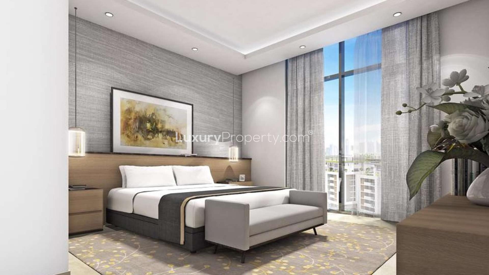 "Luxurious apartment balcony view in Sobha Hartland, Mohammed Bin Rashid City at night.",Modern bedroom in Sobha Hartland apartment, featuring elegant decor and floor-to-ceiling windows