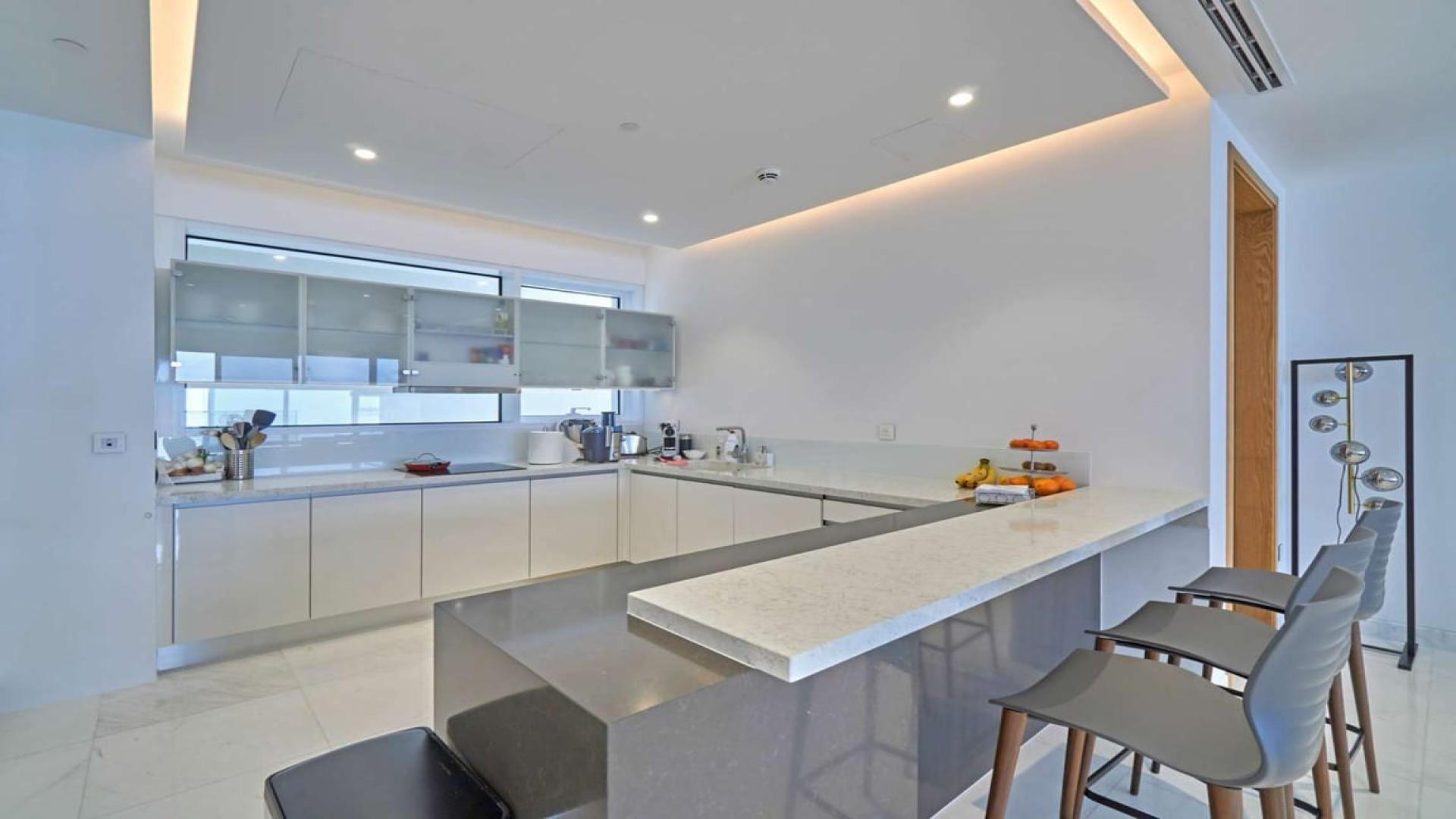 "Spacious balcony with panoramic Arabian Gulf views at 1 JBR, Jumeirah Beach Residence.",Modern kitchen in Jumeirah Beach Residence apartment, sleek design with island seating